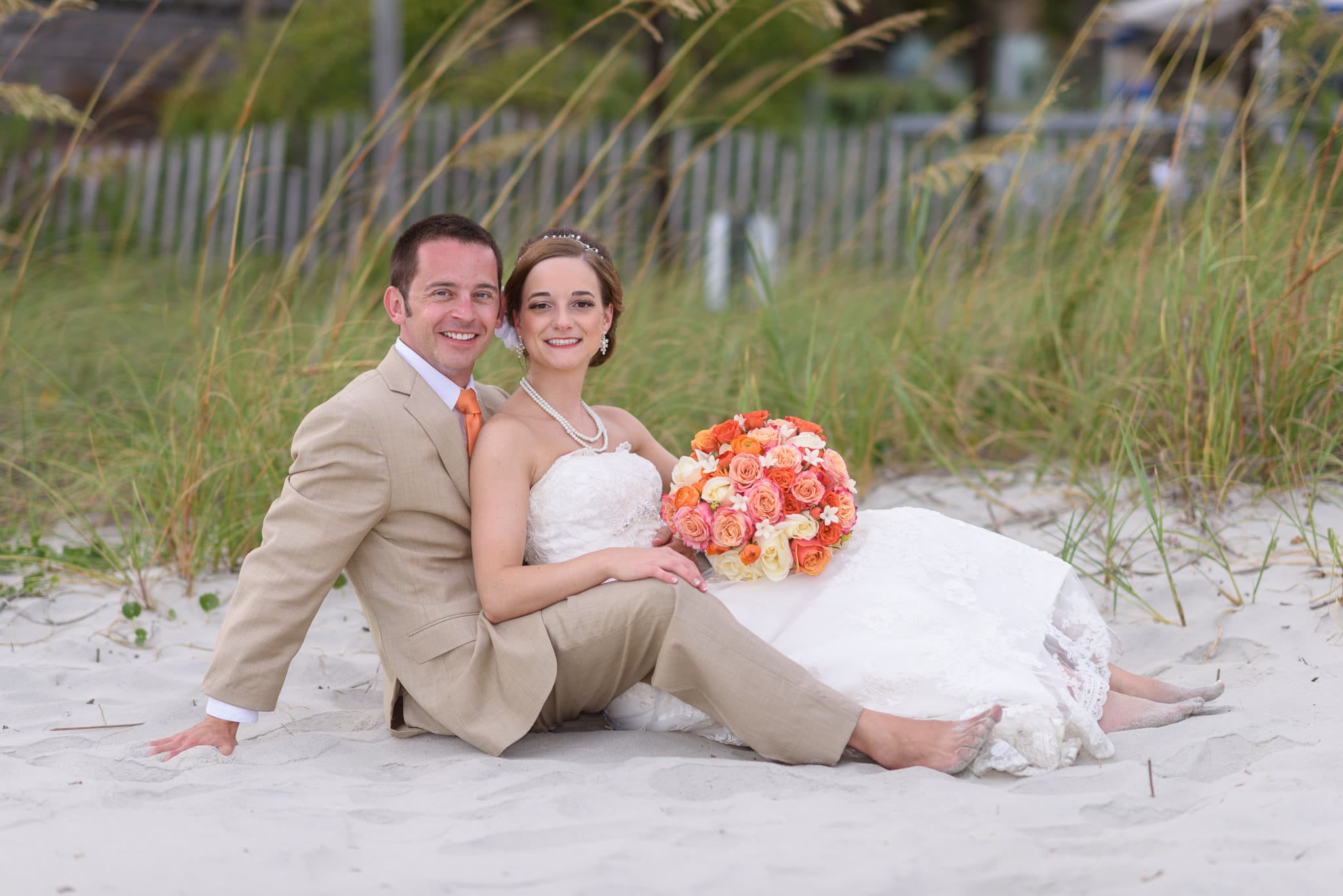 Wedding couple sitting together in front of the sea oats - Hilton at Kingston Plantation