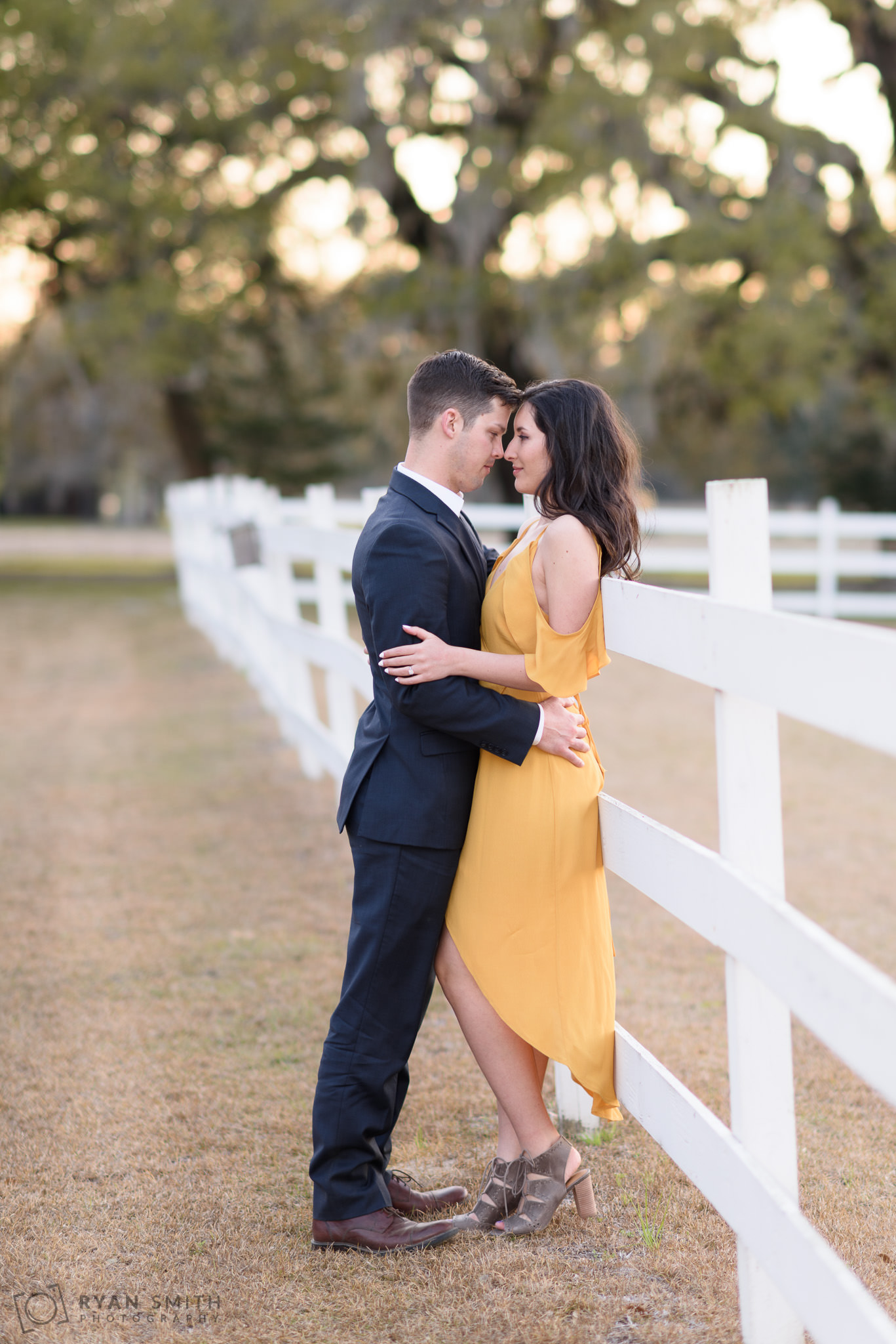 Couple leaning against the fence at sunset Mansfield Plantation, Georgetown