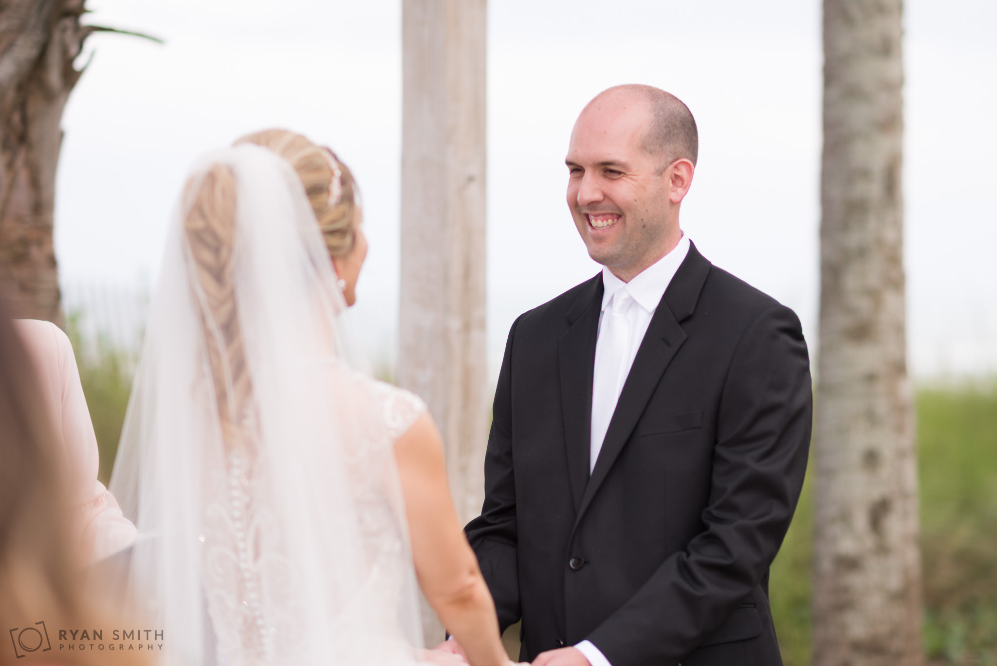 Groom smiling at bride during ceremony Hilton Myrtle Beach Resort