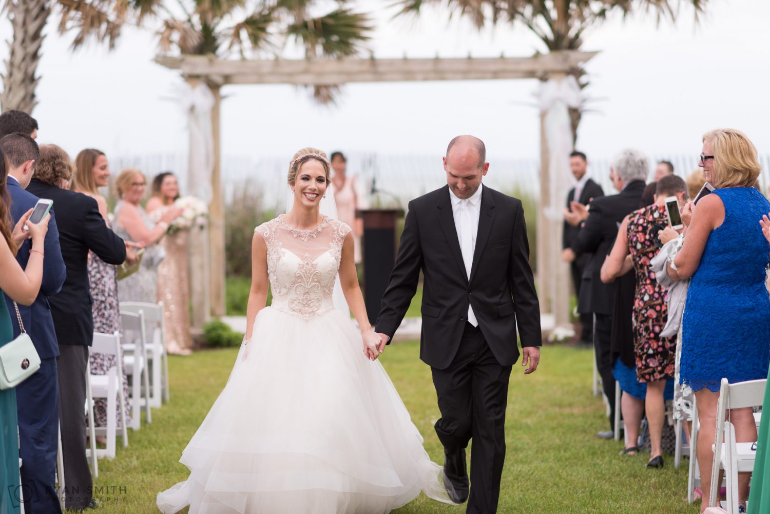 Happy bride walking down the isle with groom Hilton Myrtle Beach Resort