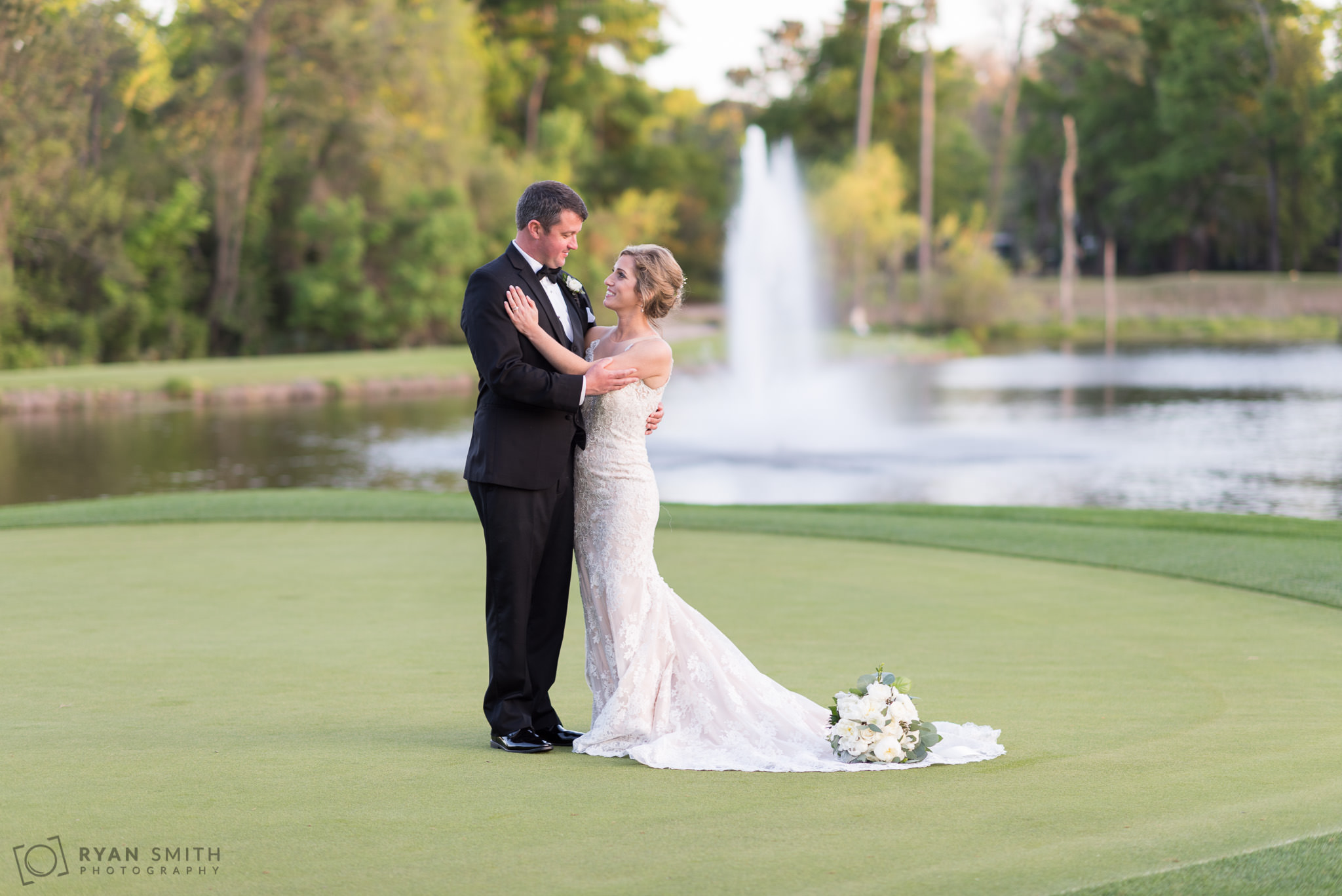 Bride and groom posing in front of the lake fountain Pawleys Plantation