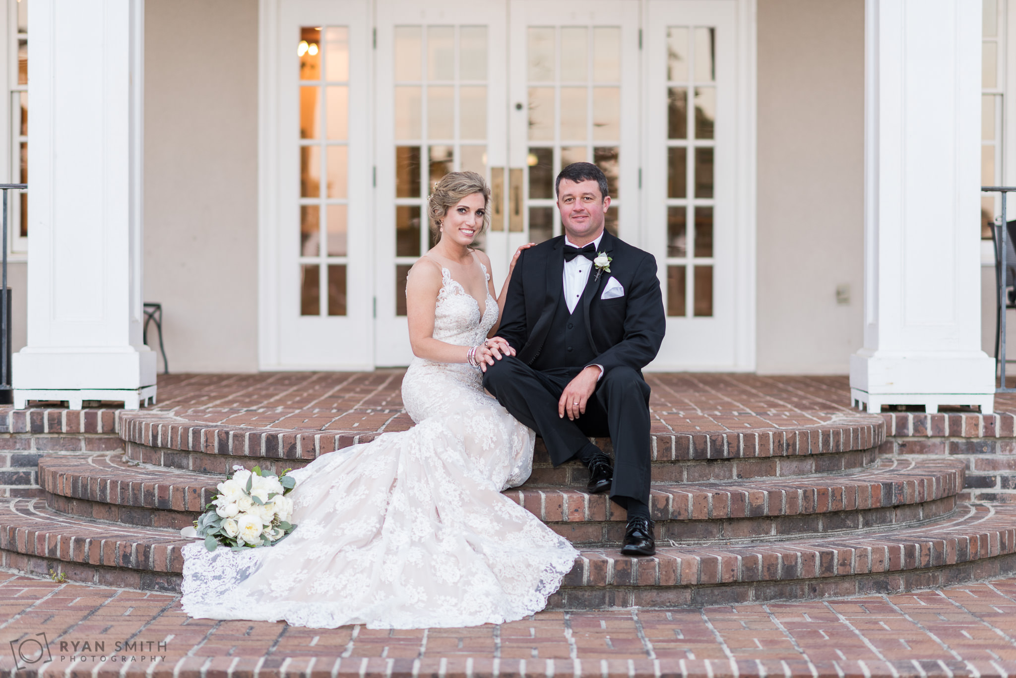 Bride and groom sitting on the steps Pawleys Plantation