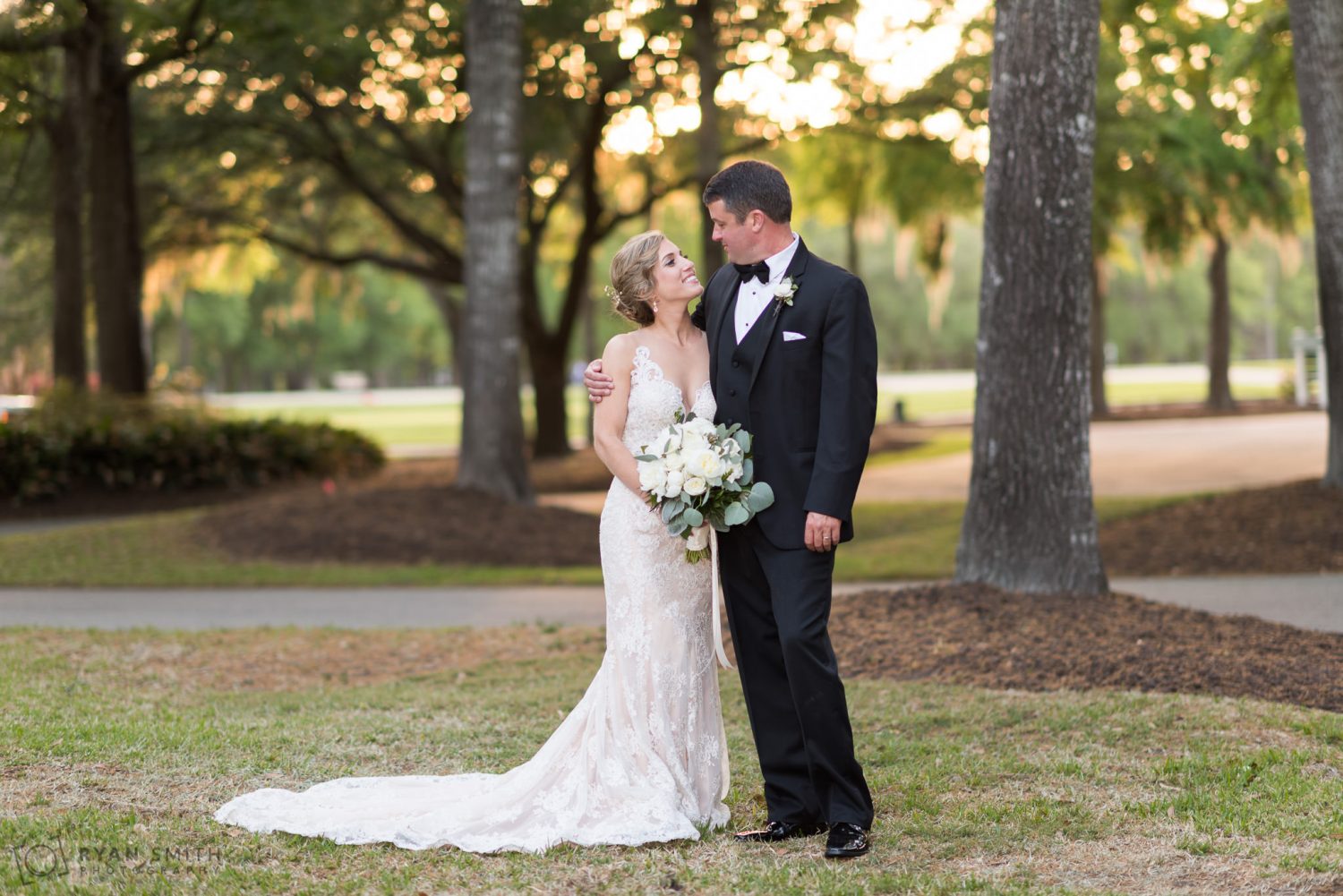 Bride and groom smiling in front of the clubhouse Pawleys Plantation