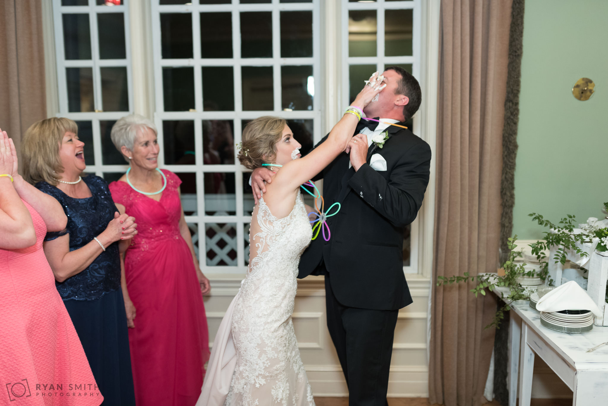 Bride smashing cake in groom's face Pawleys Plantation