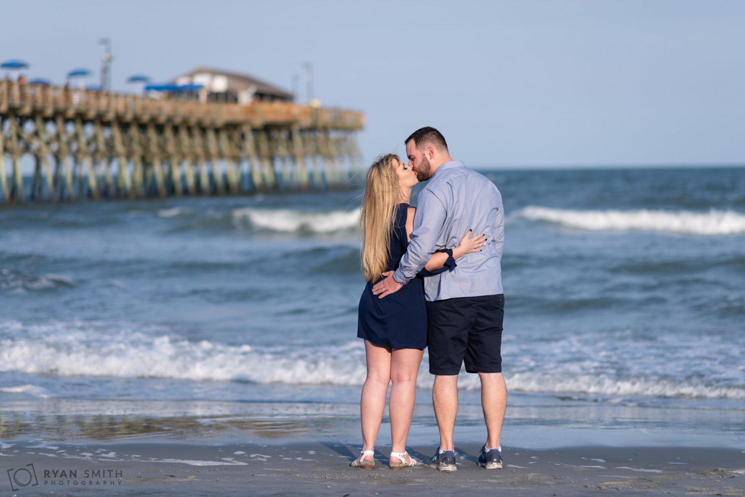 Couple kissing in front of the ocean Garden City Pier