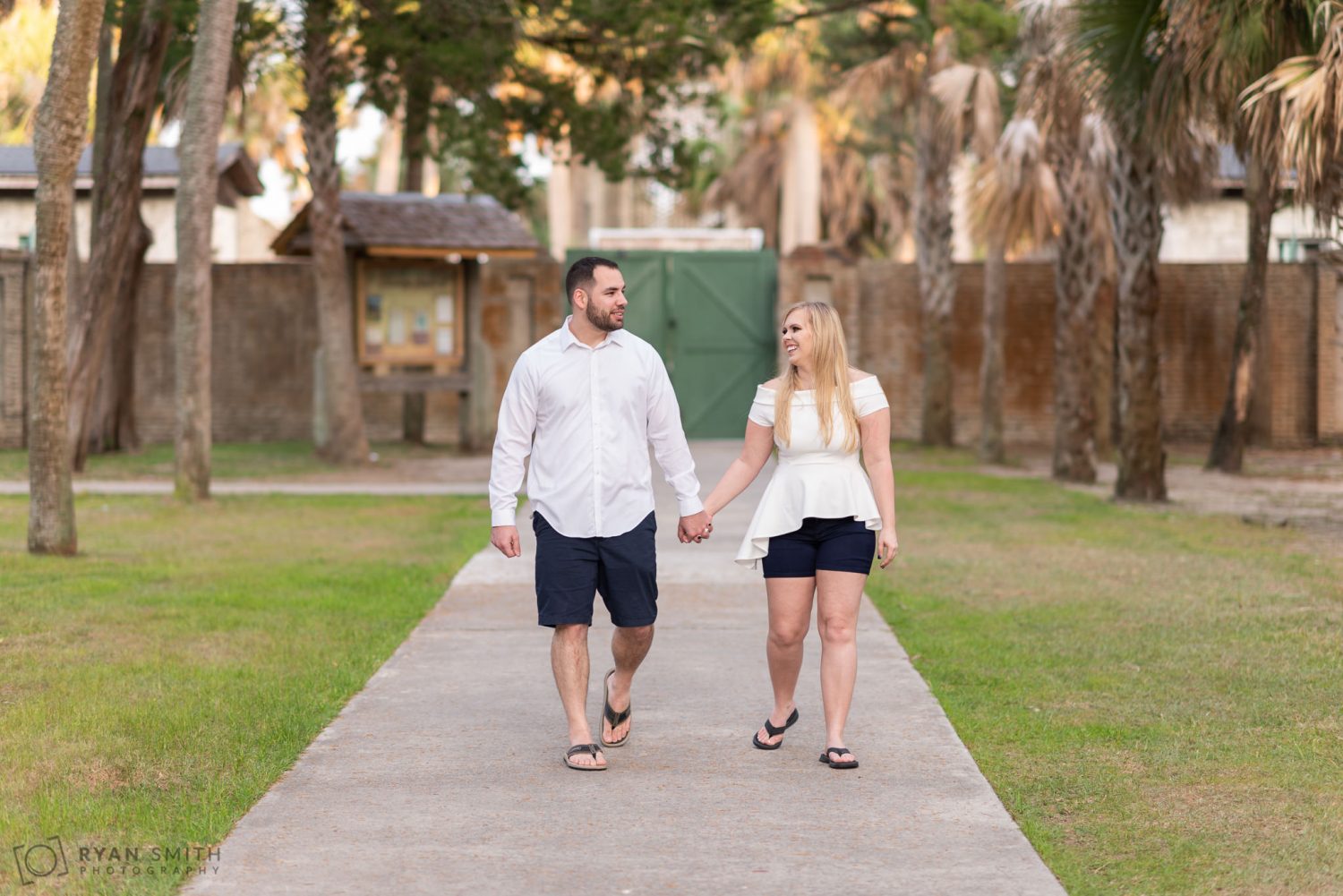 Couple walking down the path in front of the Atalaya Castle Huntington Beach State Park