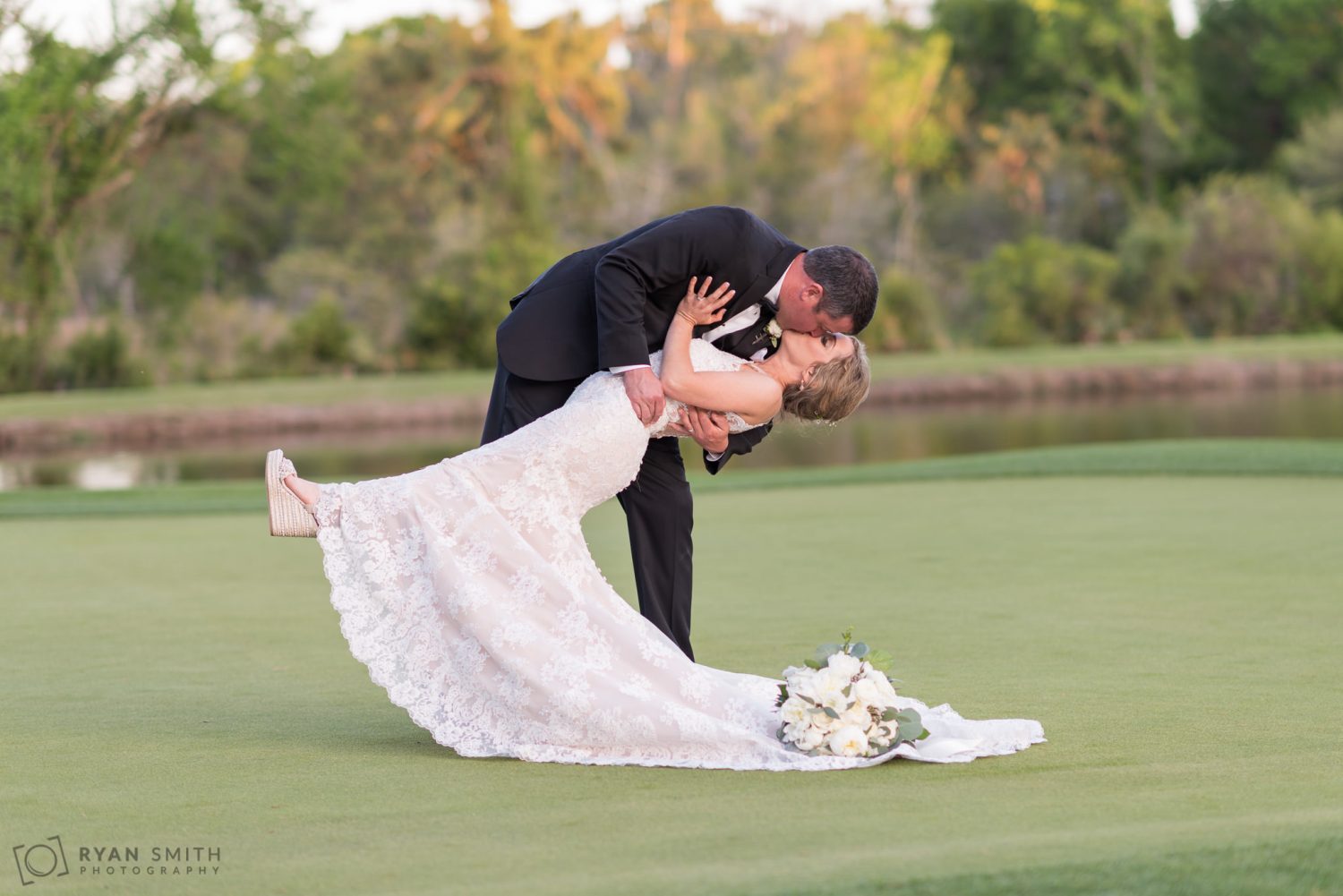 Groom doing a great dip of the bride on the green  Pawleys Plantation