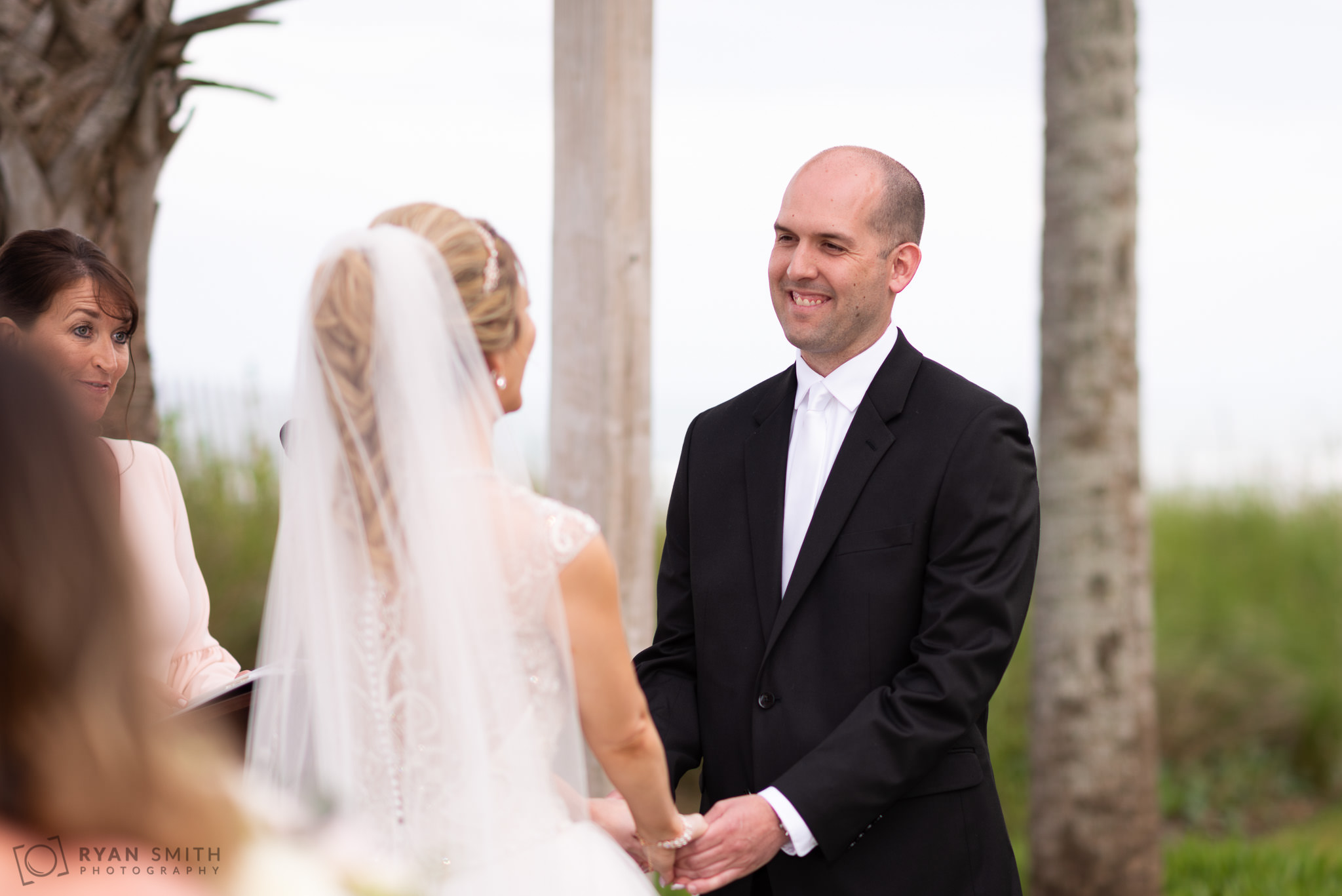 Groom smiling at bride during ceremony