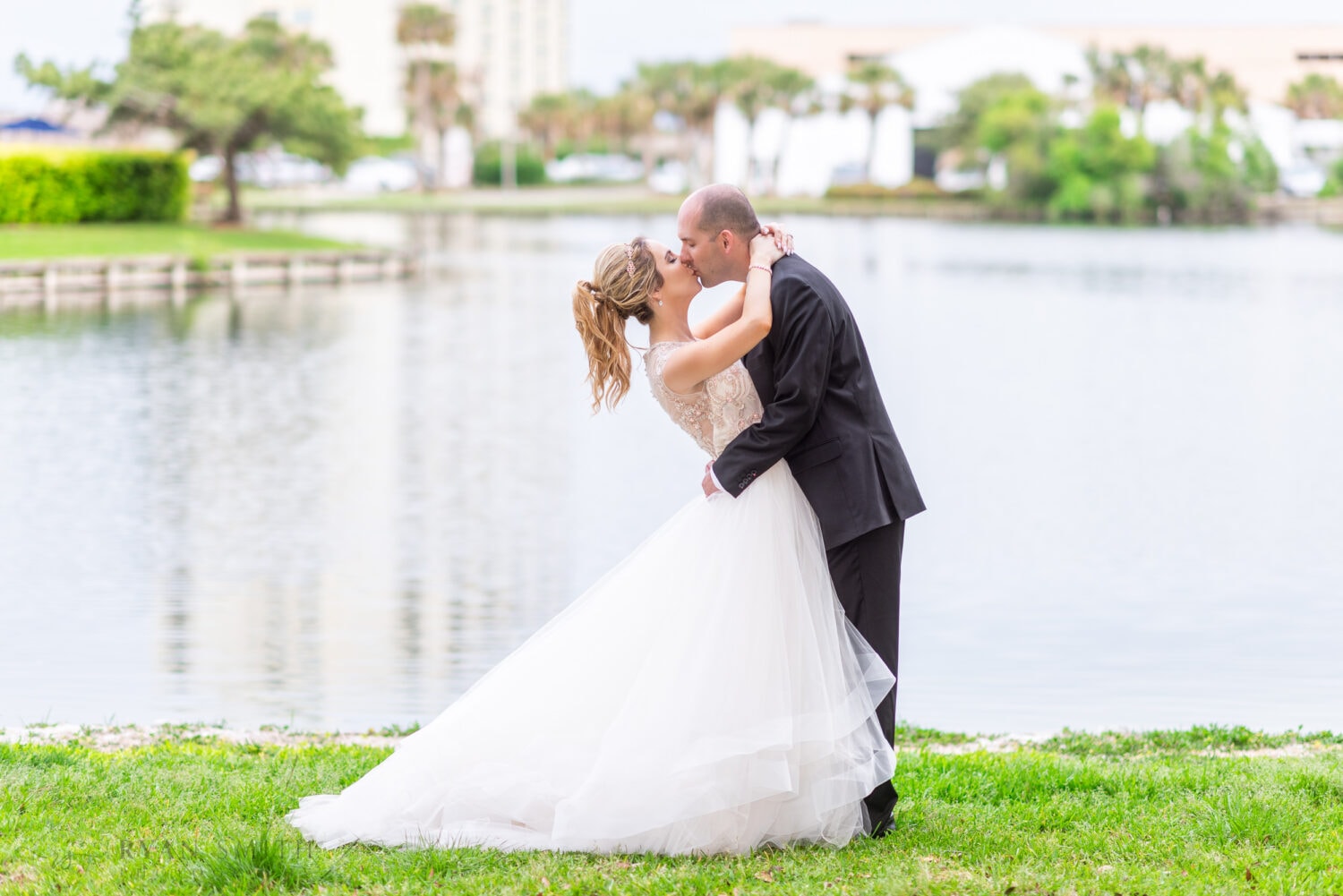 Groom leaning back bride for a kiss by the lake - Kingston Plantation Myrtle Beach