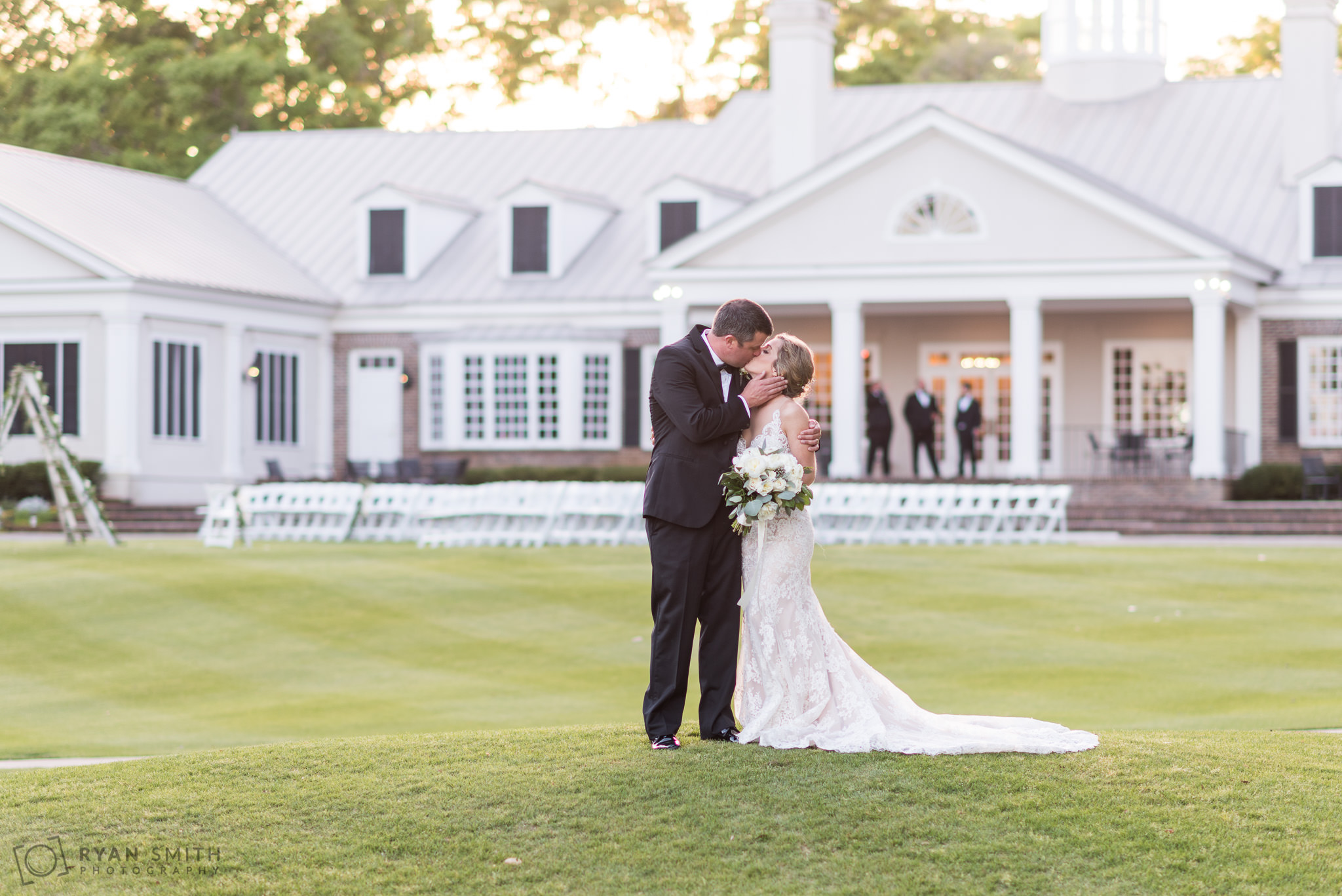 Kiss on the golf course with the clubhouse in the background Pawleys Plantation