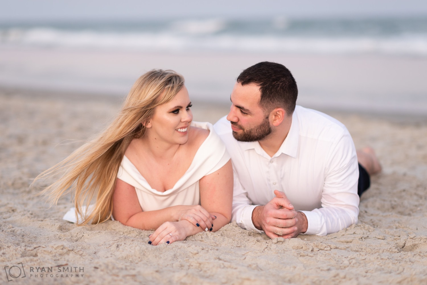 Laying in the sand engagement portrait - Huntington Beach State Park