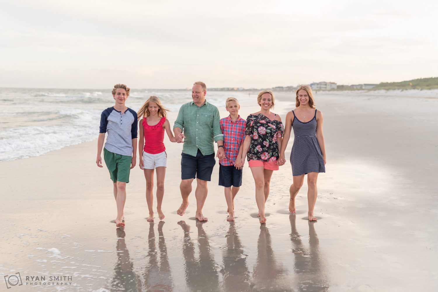 Family having fun walking down the beach together Huntington Beach State Park