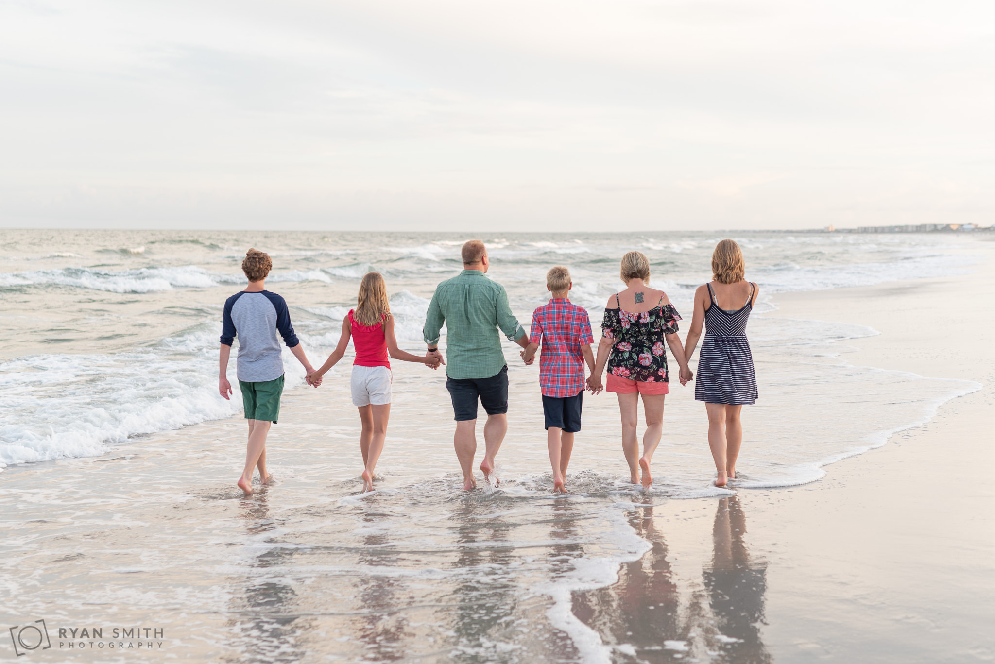 Family having fun walking down the beach together Huntington Beach State Park