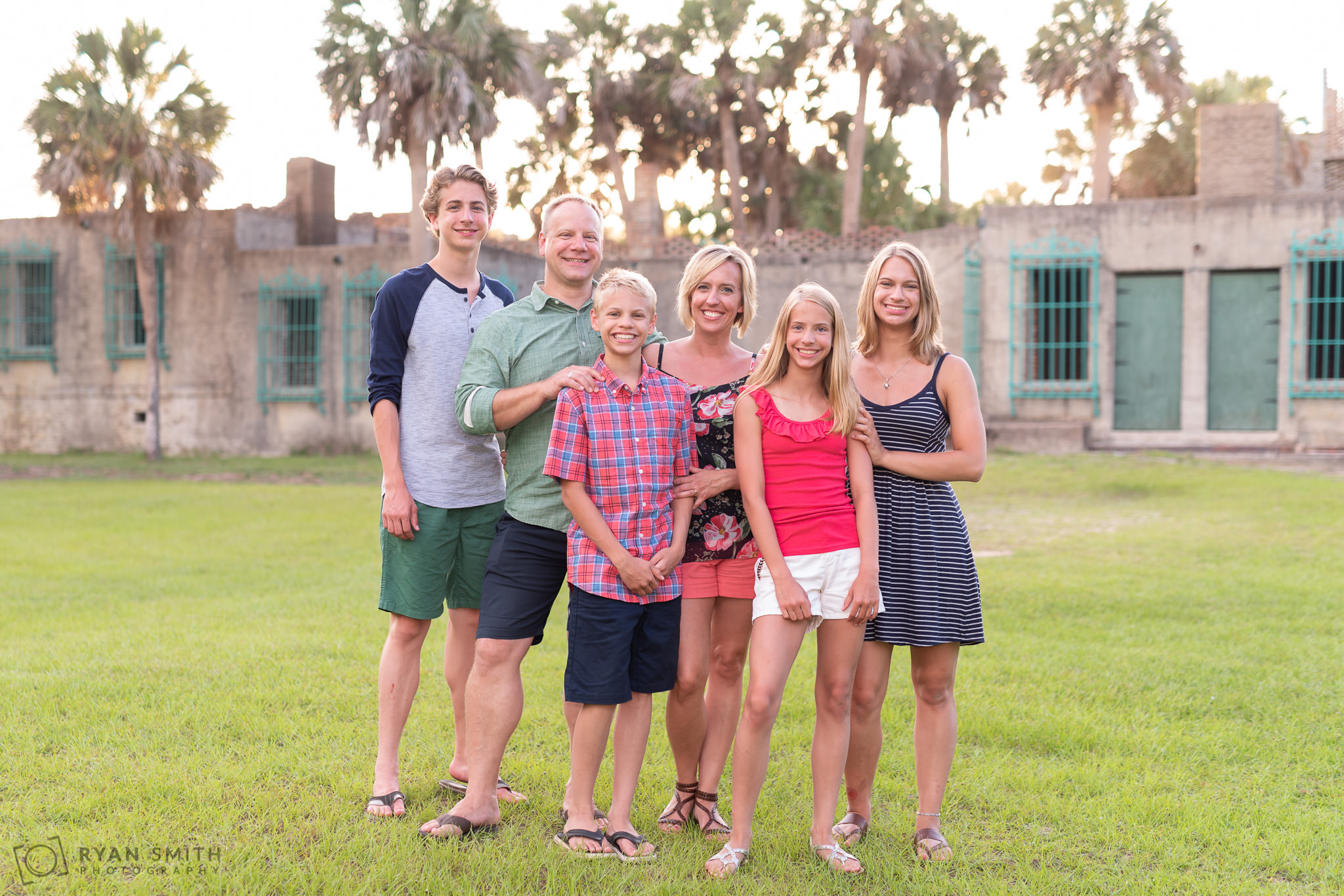 Family portrait with the Atalaya castle and palm trees in background Huntington Beach State Park