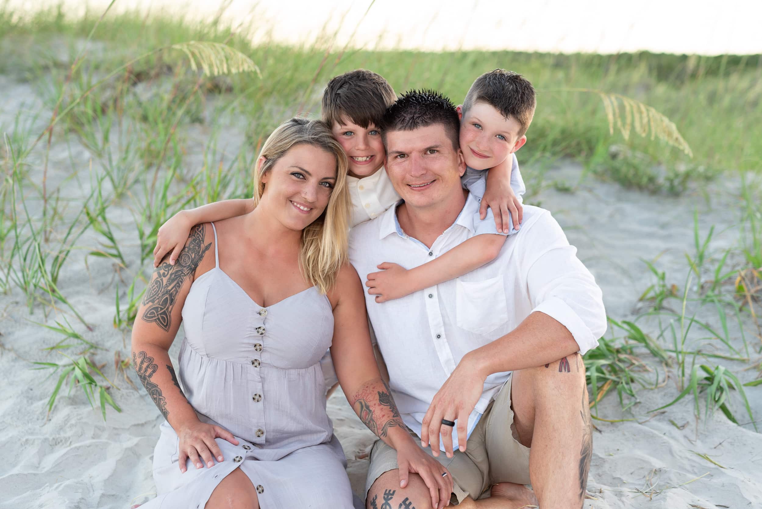Cute family of 4 sitting by the dunes - Huntington Beach State Park