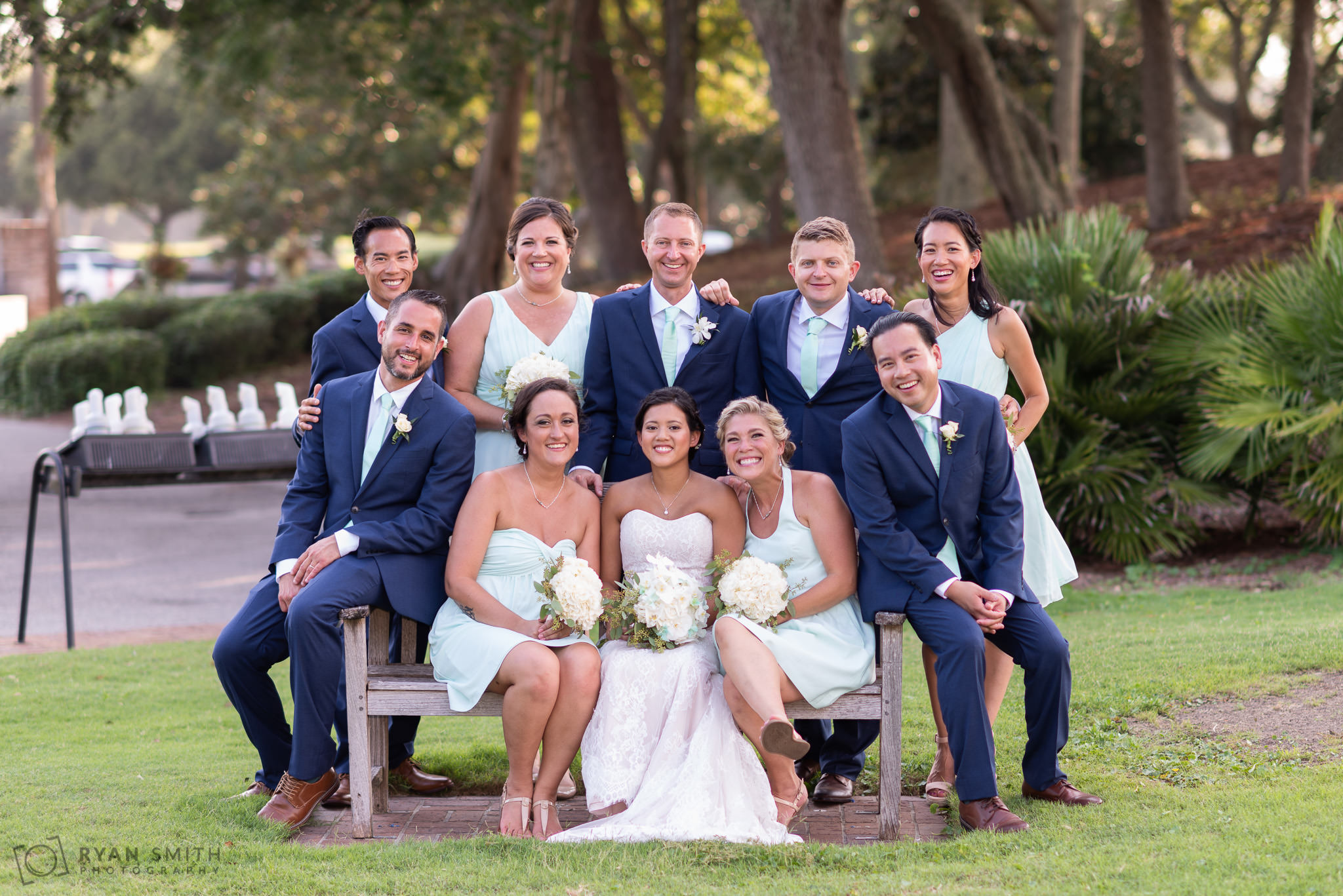 Bridal party sitting on a golf course bench Dunes Golf and Beach Club