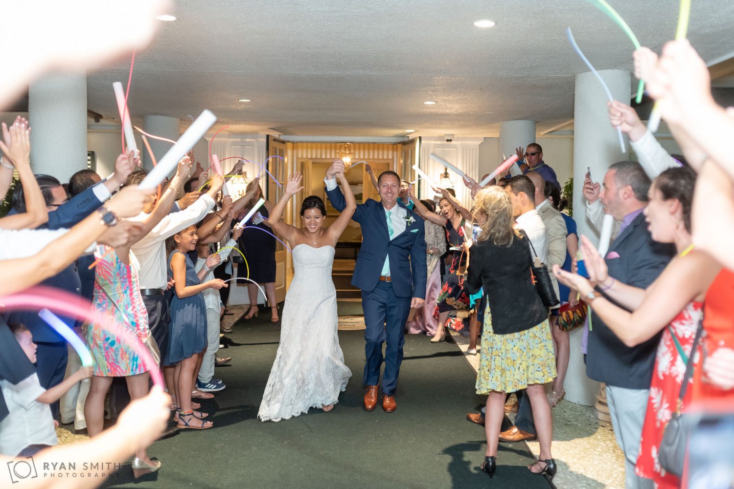 Bride and groom exit with glowsticks Dunes Golf and Beach Club