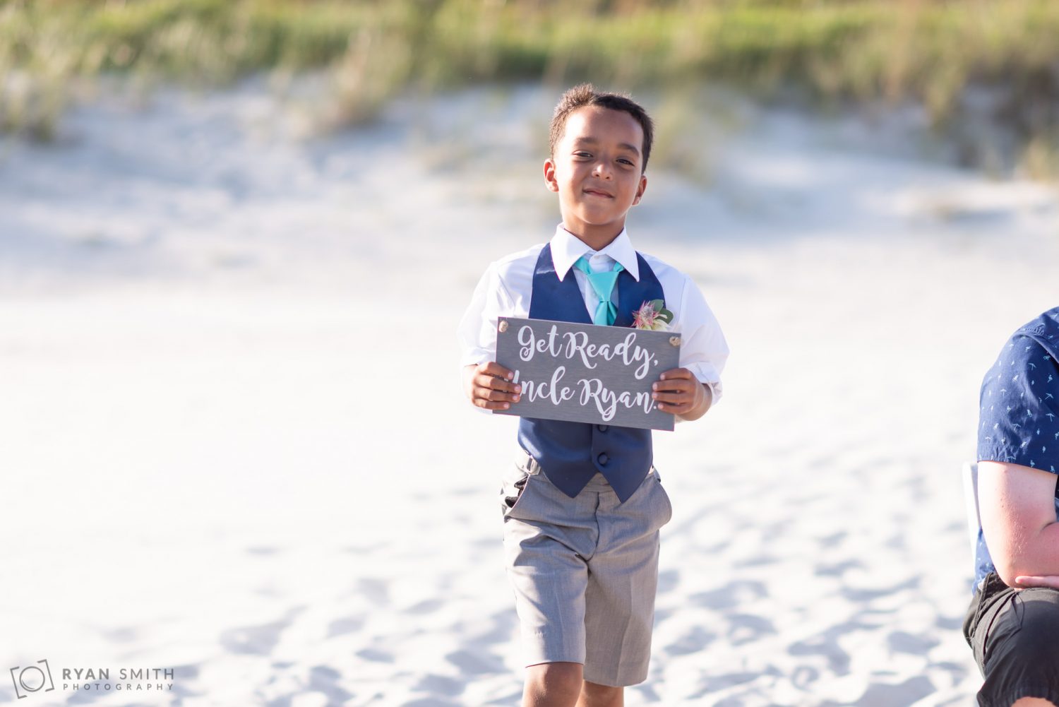 Boy carrying sign in front of bride Grande Dunes Ocean Club