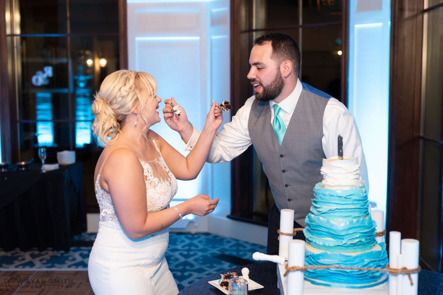 Bride and groom feeding cake Grande Dunes Ocean Club