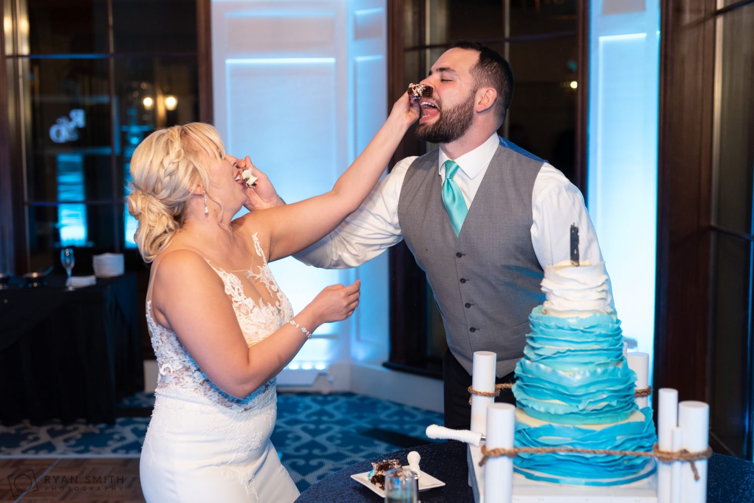 Bride putting cake on groom's nose Grande Dunes Ocean Club