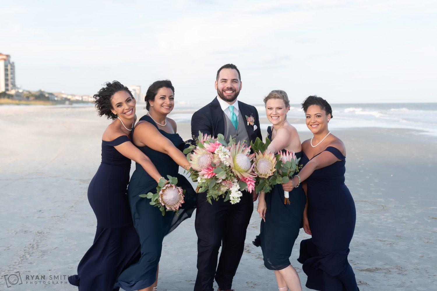 Groom holding the flowers with the bridesmaids Grande Dunes Ocean Club