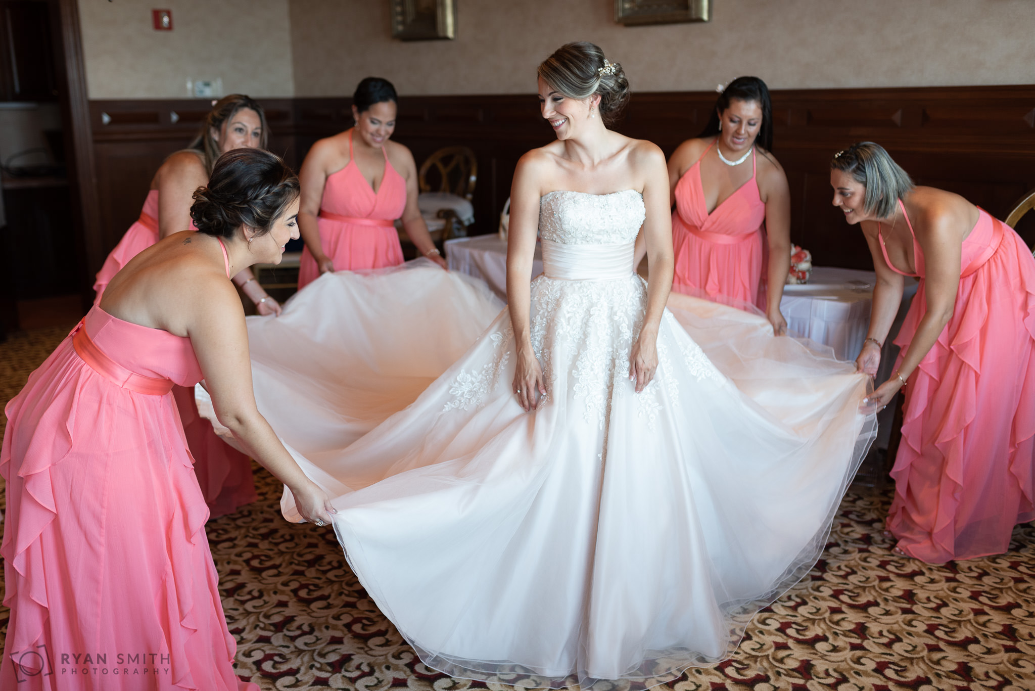 Bridesmaids fluffing  bride's dress before the wedding Grande Dunes Ocean Club