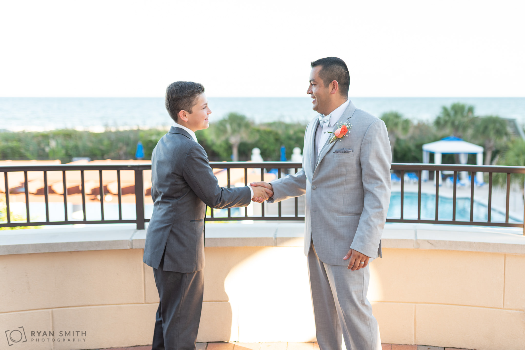 Son shaking father's hand after the wedding Grande Dunes Ocean Club