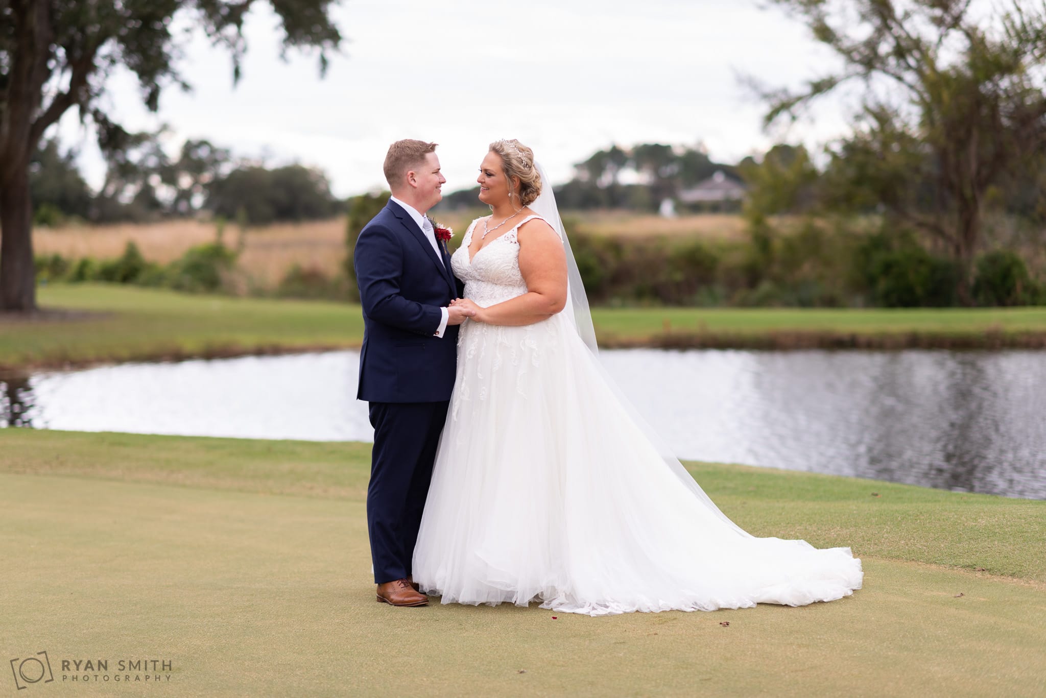 Bride and groom holding hands on the golf course