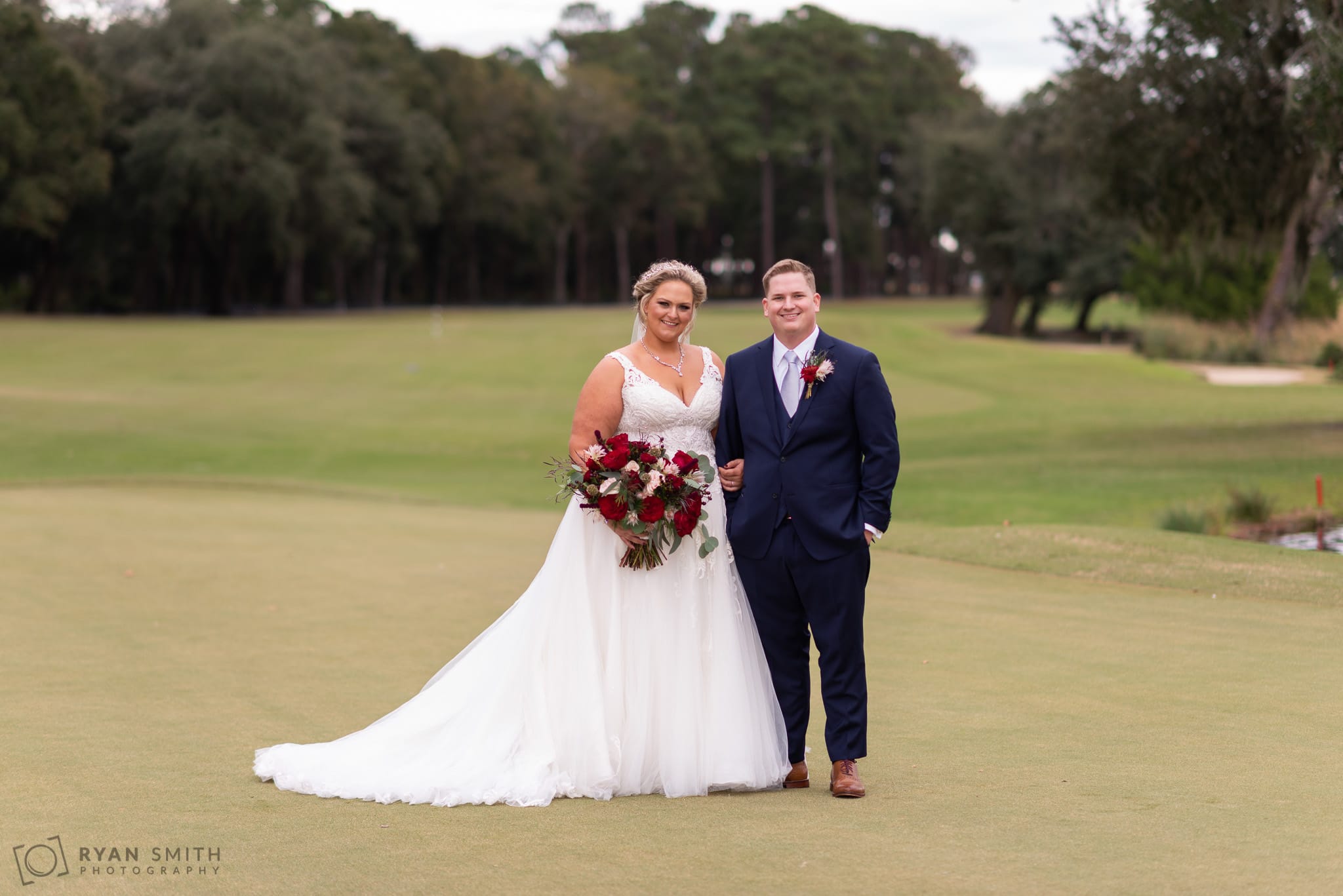 Bride and groom standing on the golf course