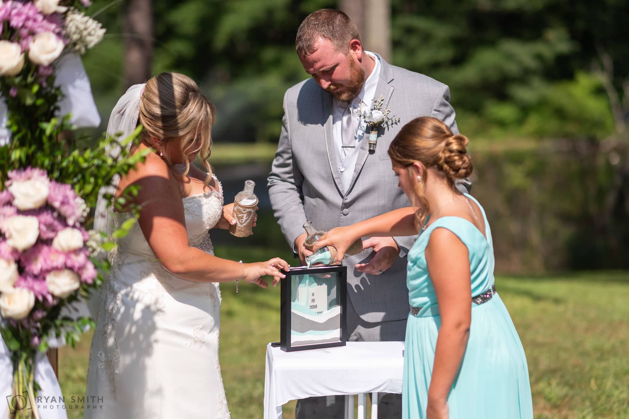 Bride, groom and daughter pouring in the sand Wildberry Farm