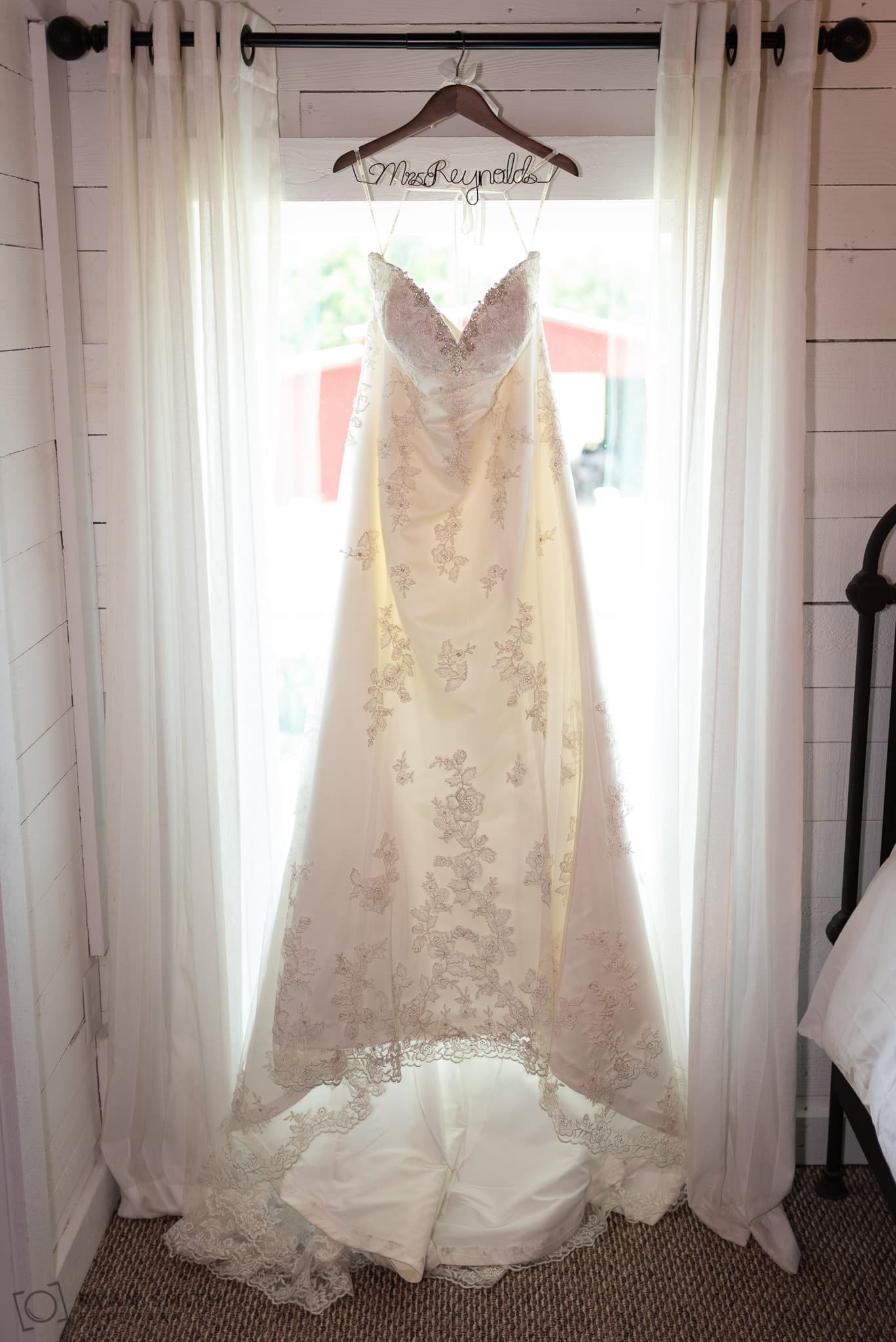 Bride's dress hanging in the window Wildberry Farm