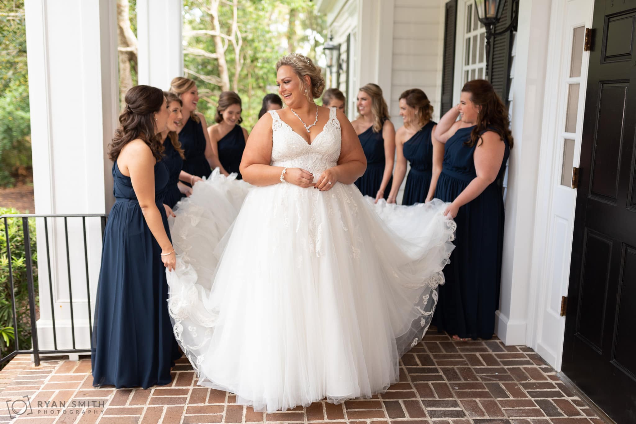 Bridesmaids fluffing bride's dress