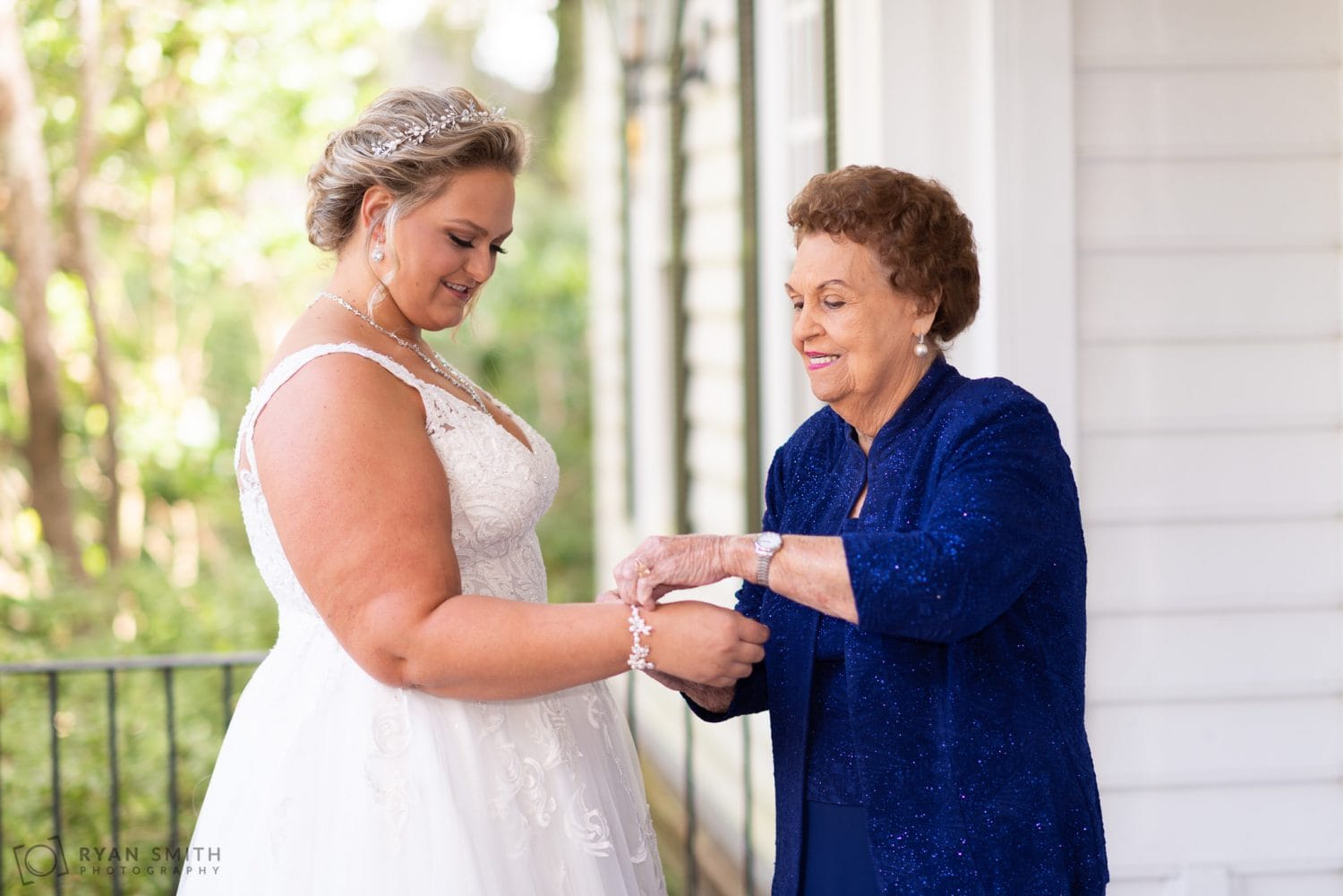 Grandmother helping bride put on her bracelet