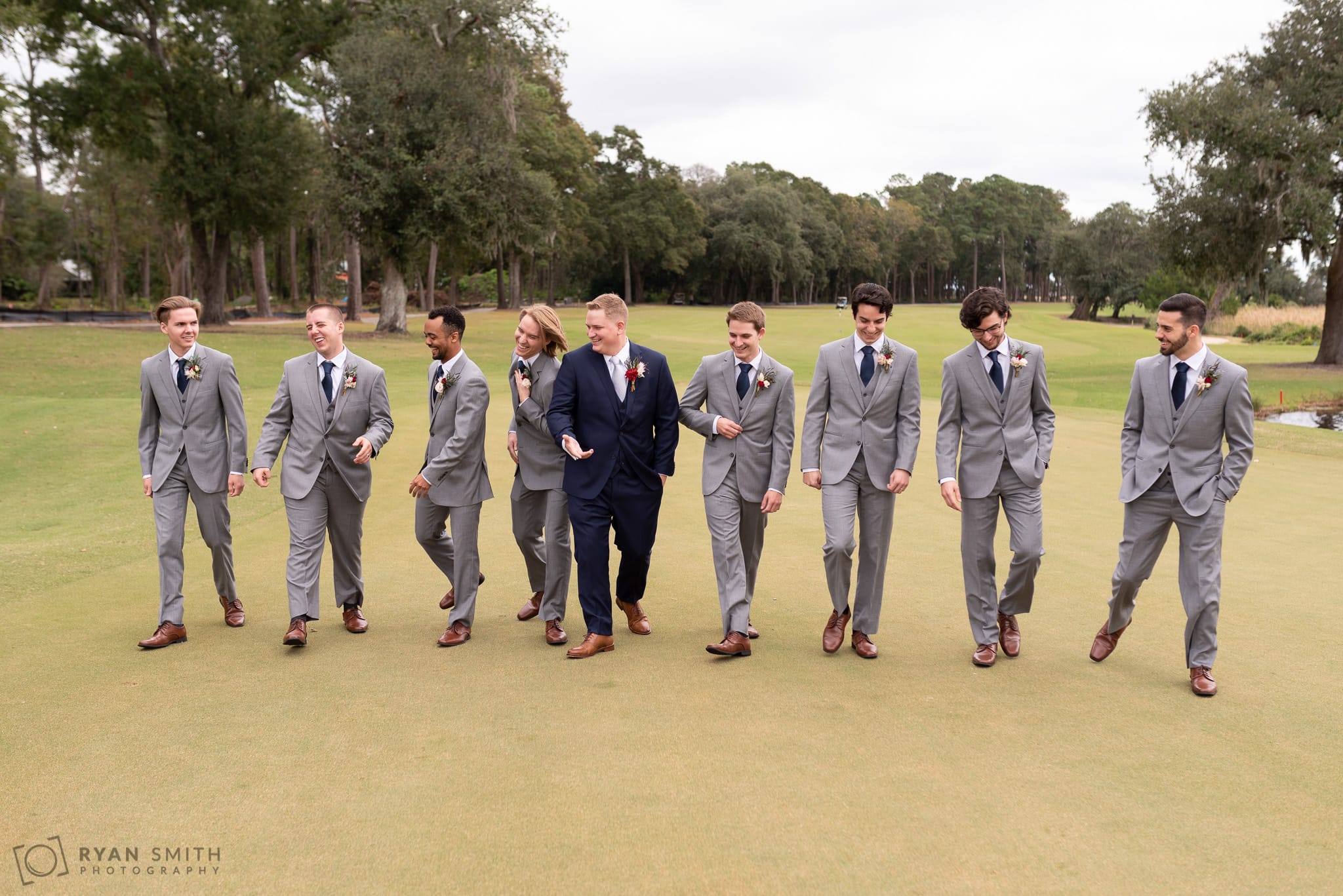 Groomsmen walking down the golf course and talking