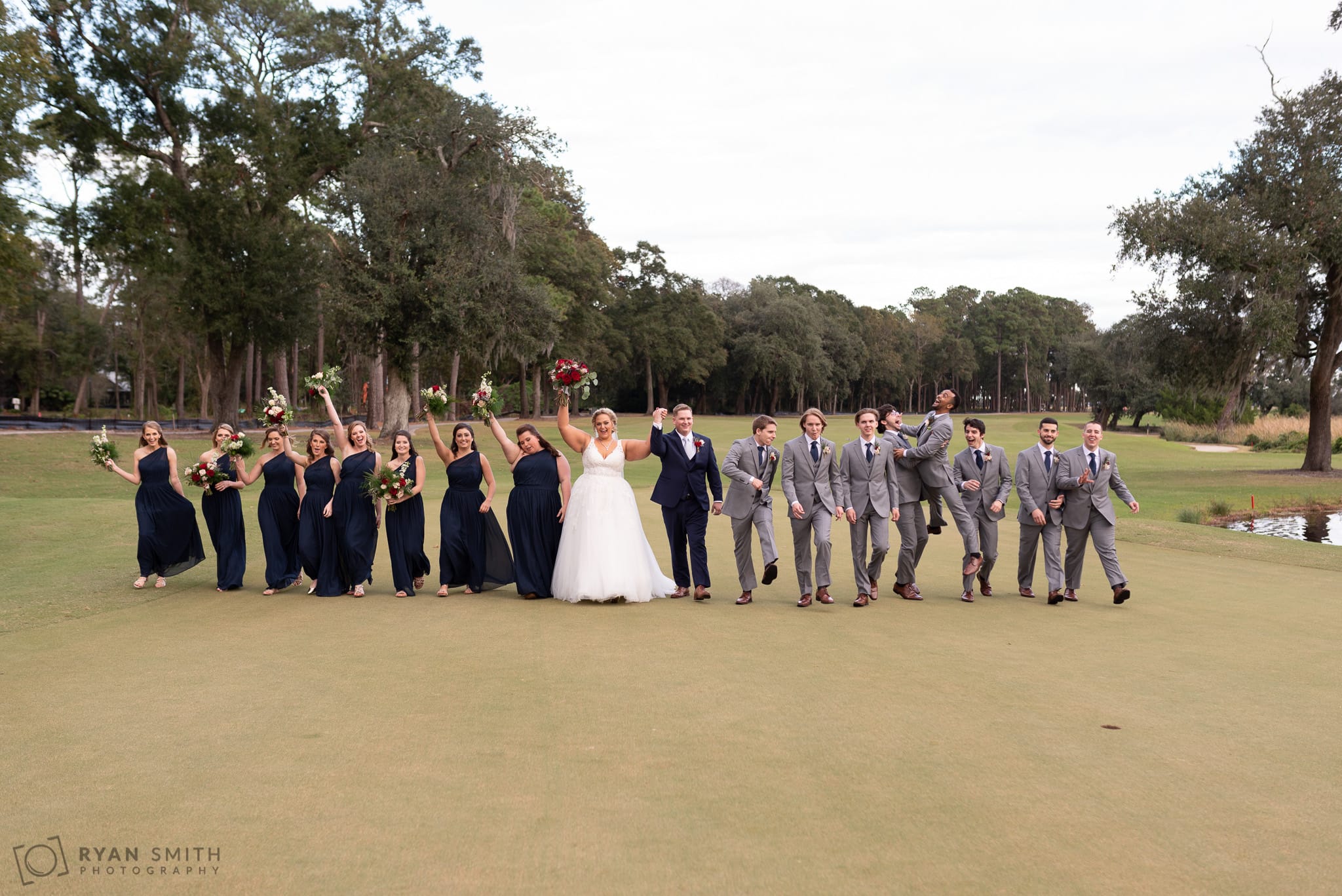 Huge bridal party walking down the golf course having fun