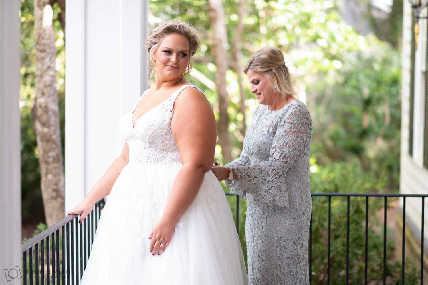 Mom helping bride with her dress