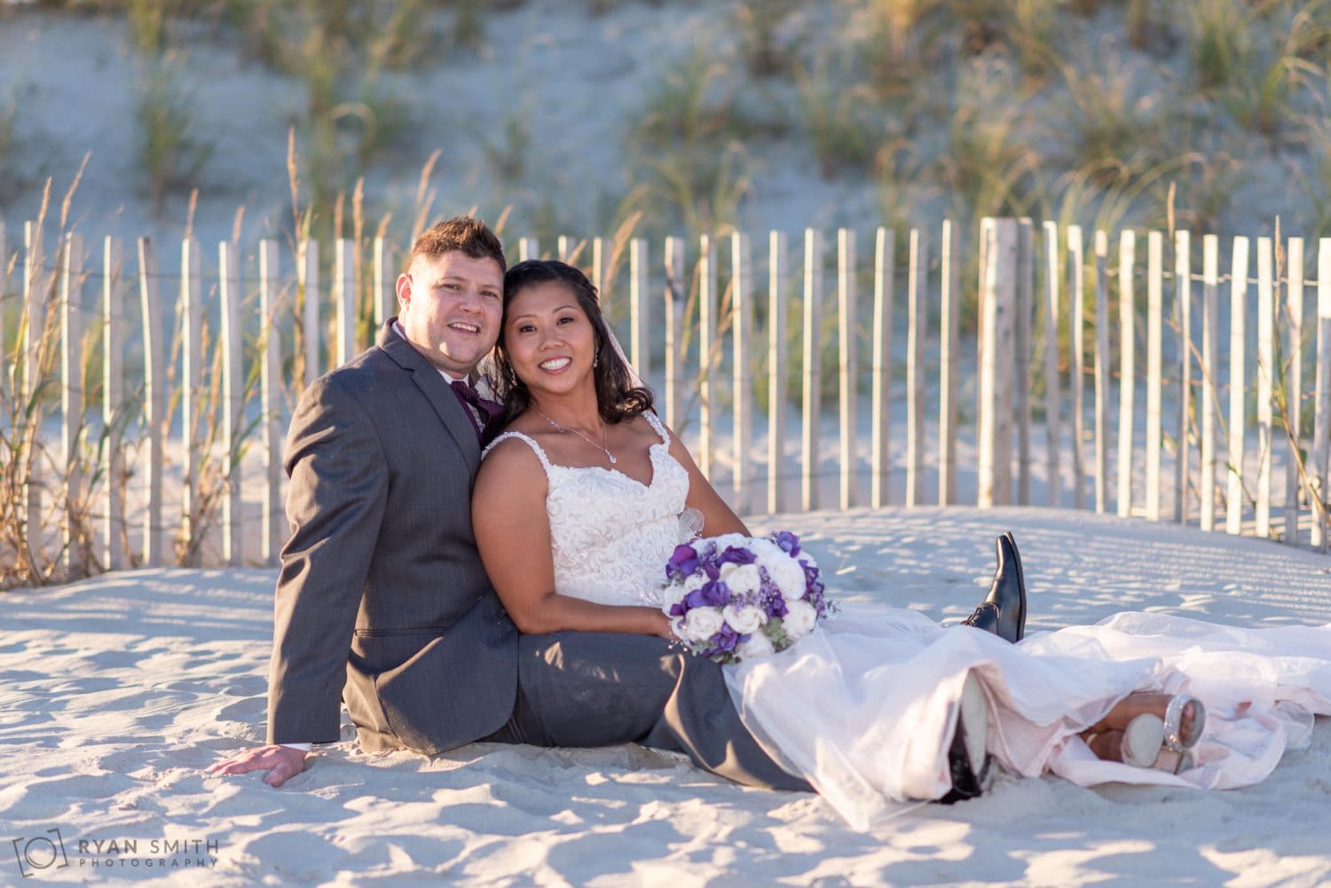 Bride and groom laying in the sand 21 Main Events at North Beach