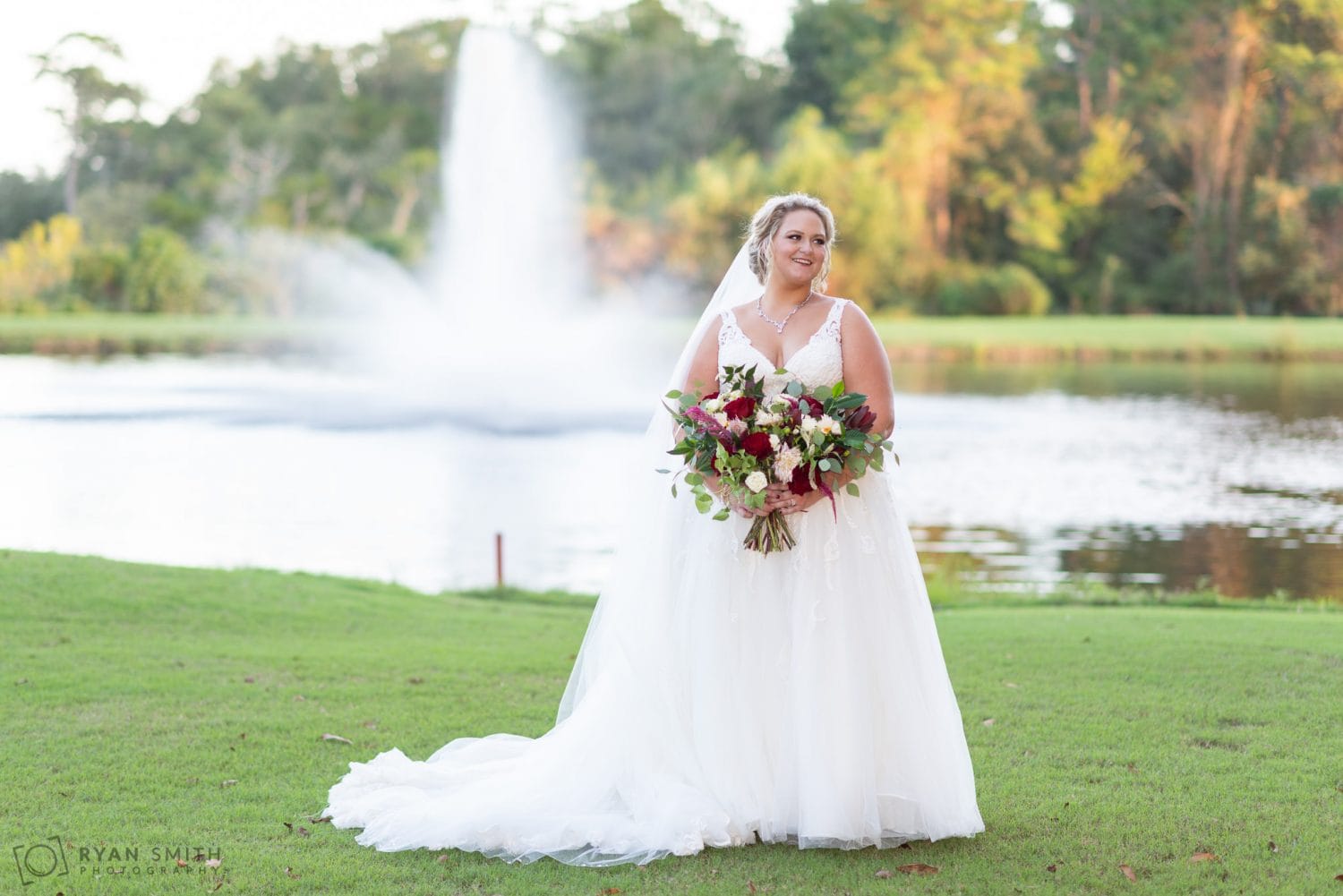 Bride laughing in front of the fountain  Pawleys Plantation Golf & Country Club