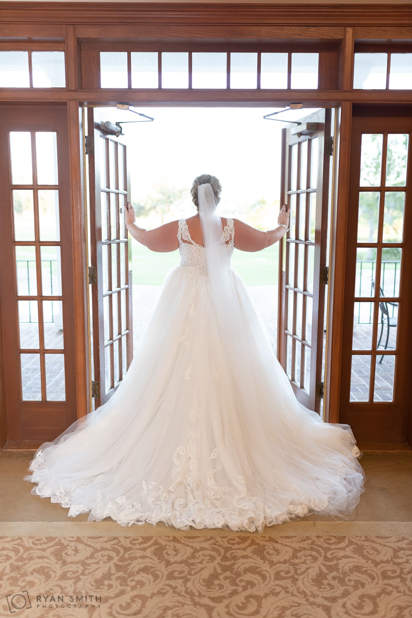 Bride looking out of the back doors Pawleys Plantation Golf & Country Club