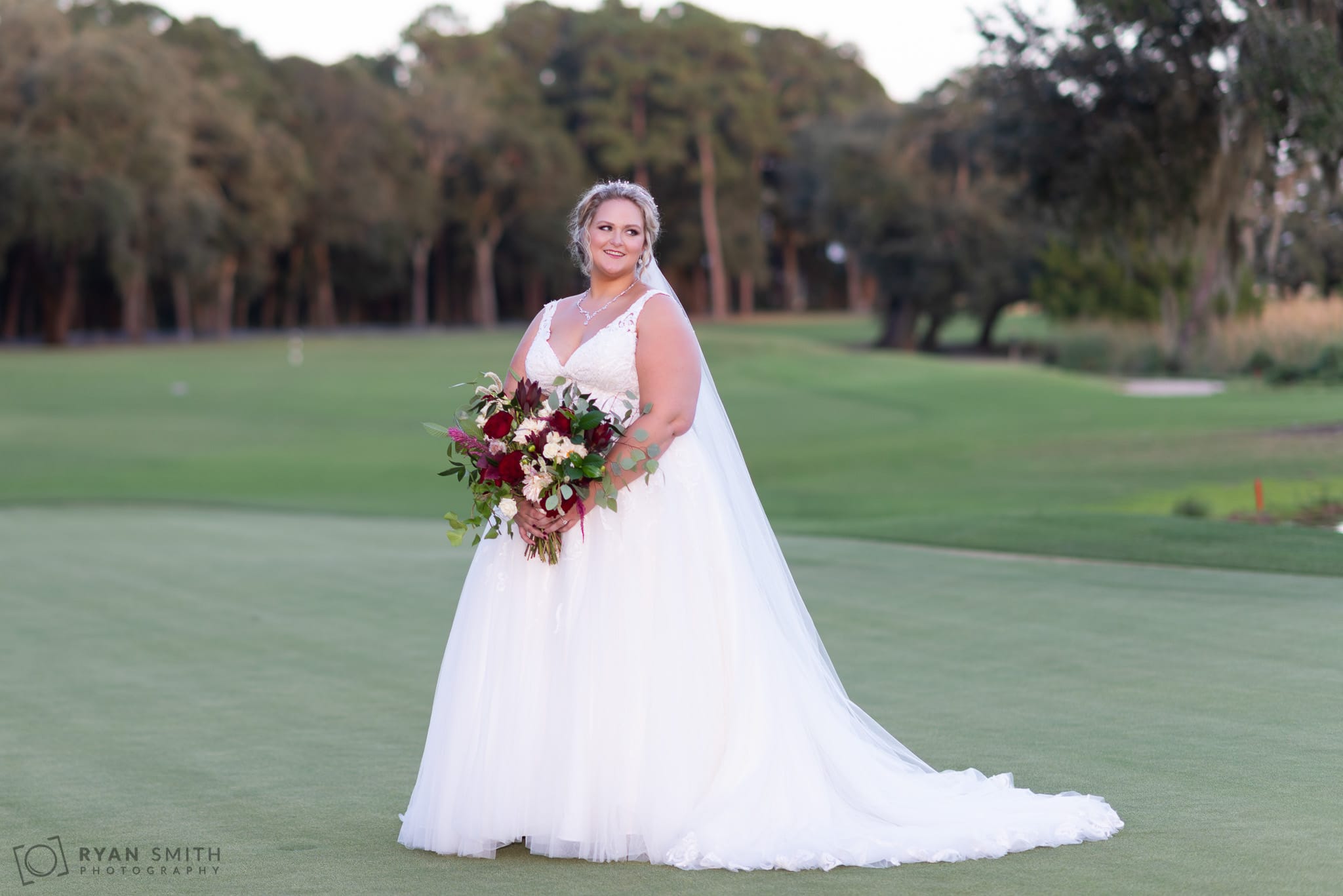 Bride looking over her shoulder standing on the golf course Pawleys Plantation Golf & Country Club