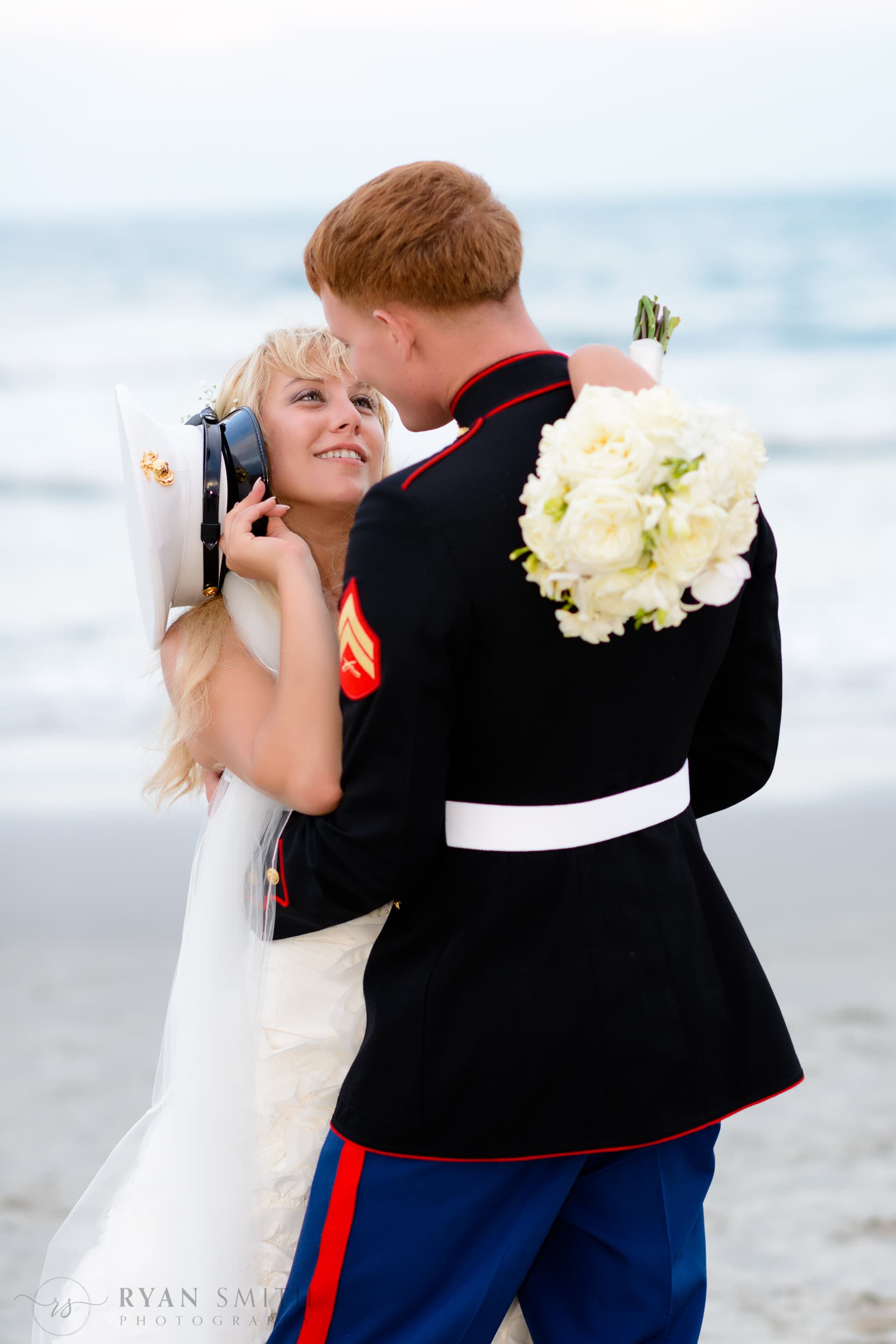 Bride looking up at groom in military uniform -