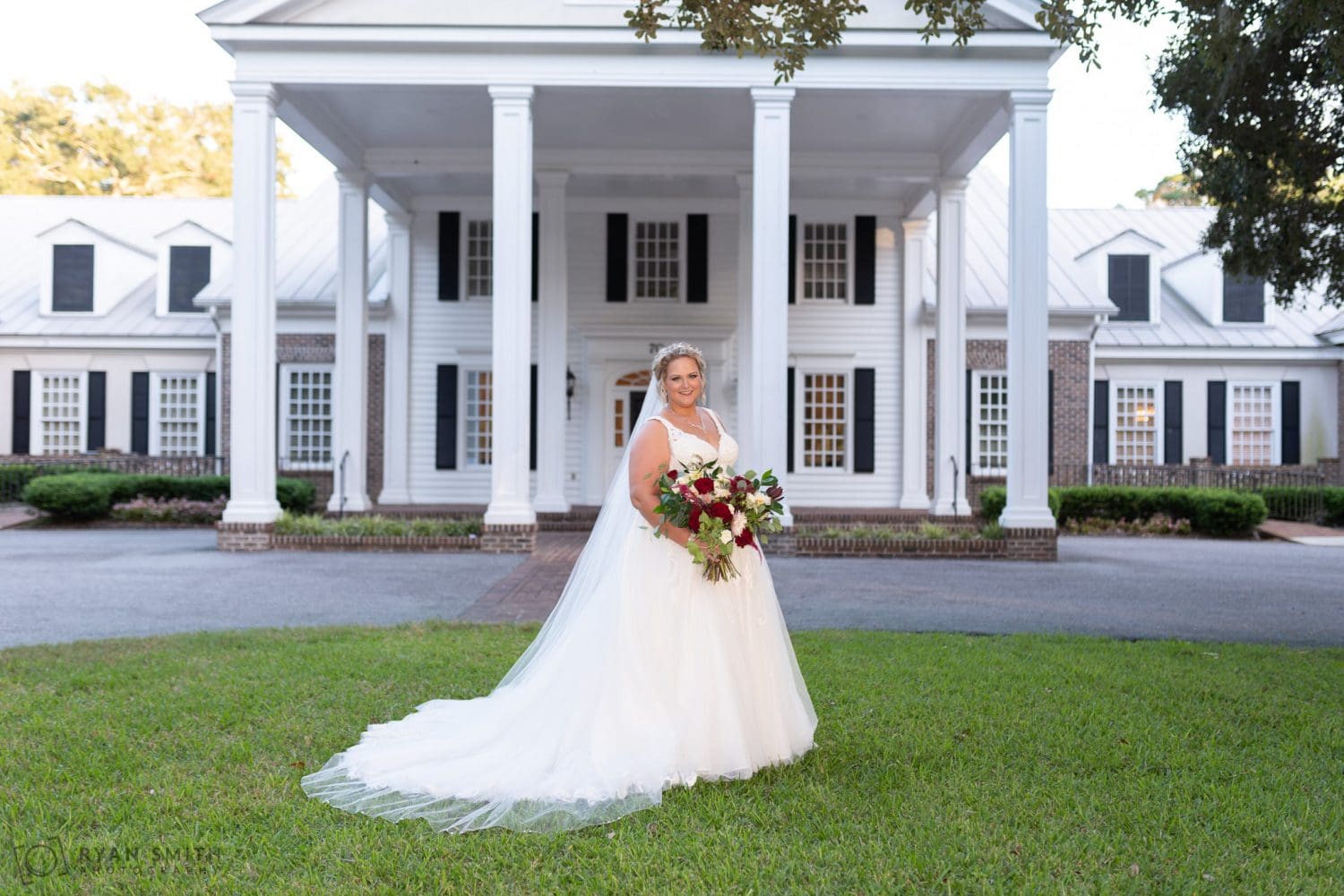 Bride smiling in front of the clubhouse Pawleys Plantation Golf & Country Club