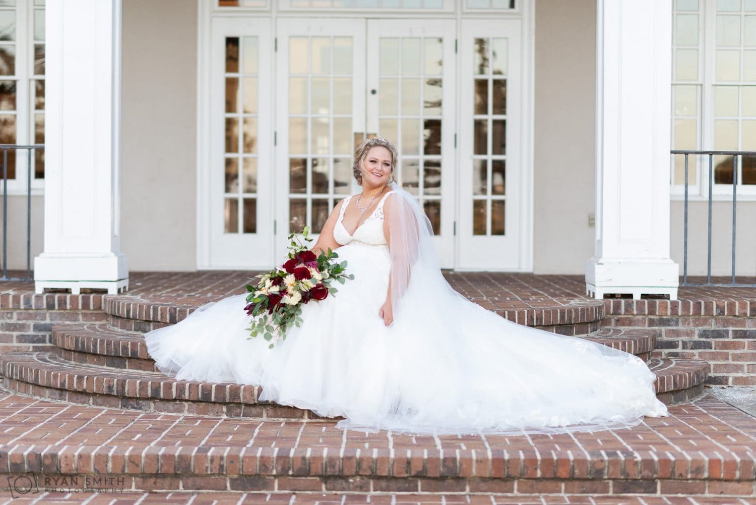 Bride smiling on the back steps Pawleys Plantation Golf & Country Club