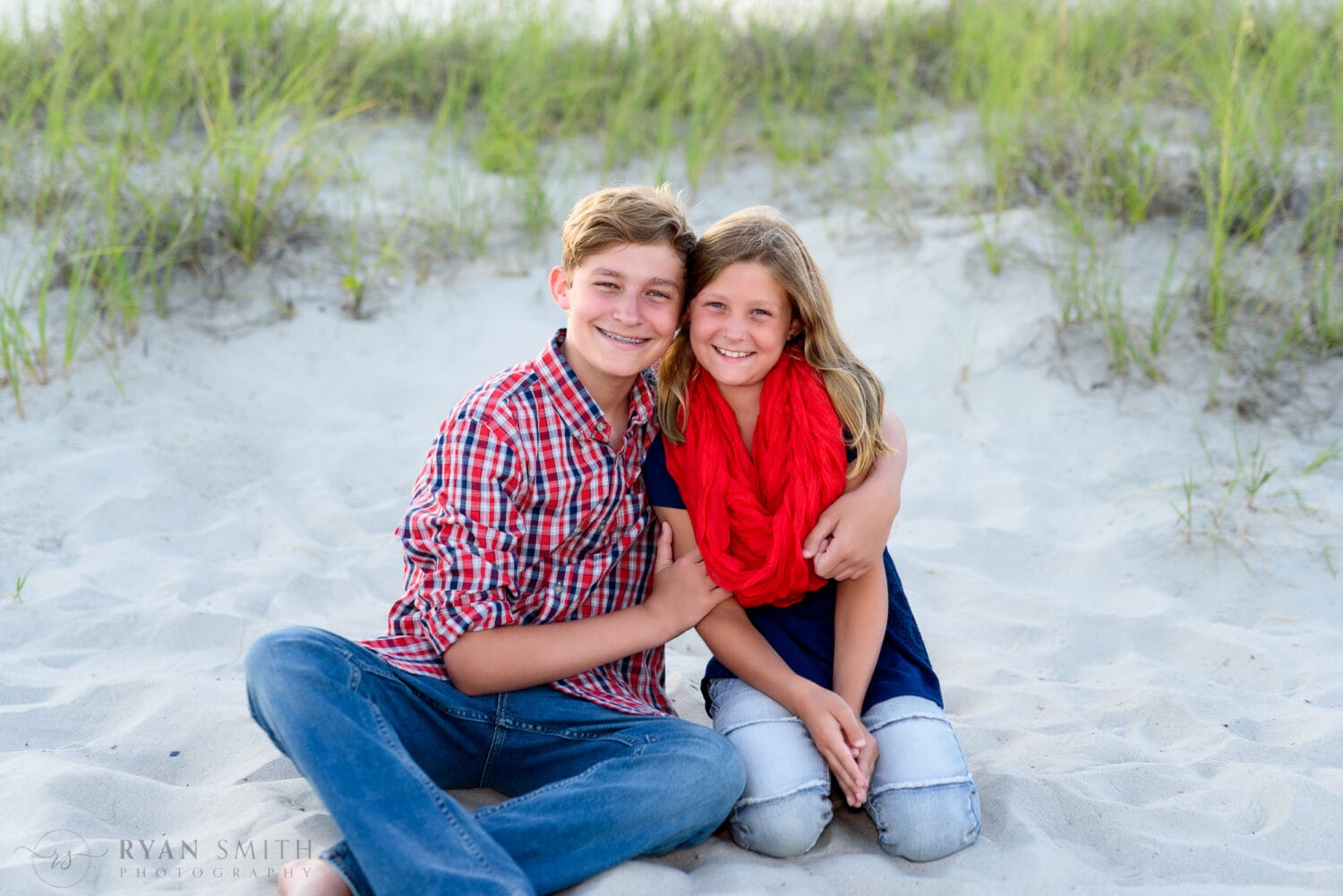 Brother with little sister sitting by the dunes - Myrtle Beach State Park