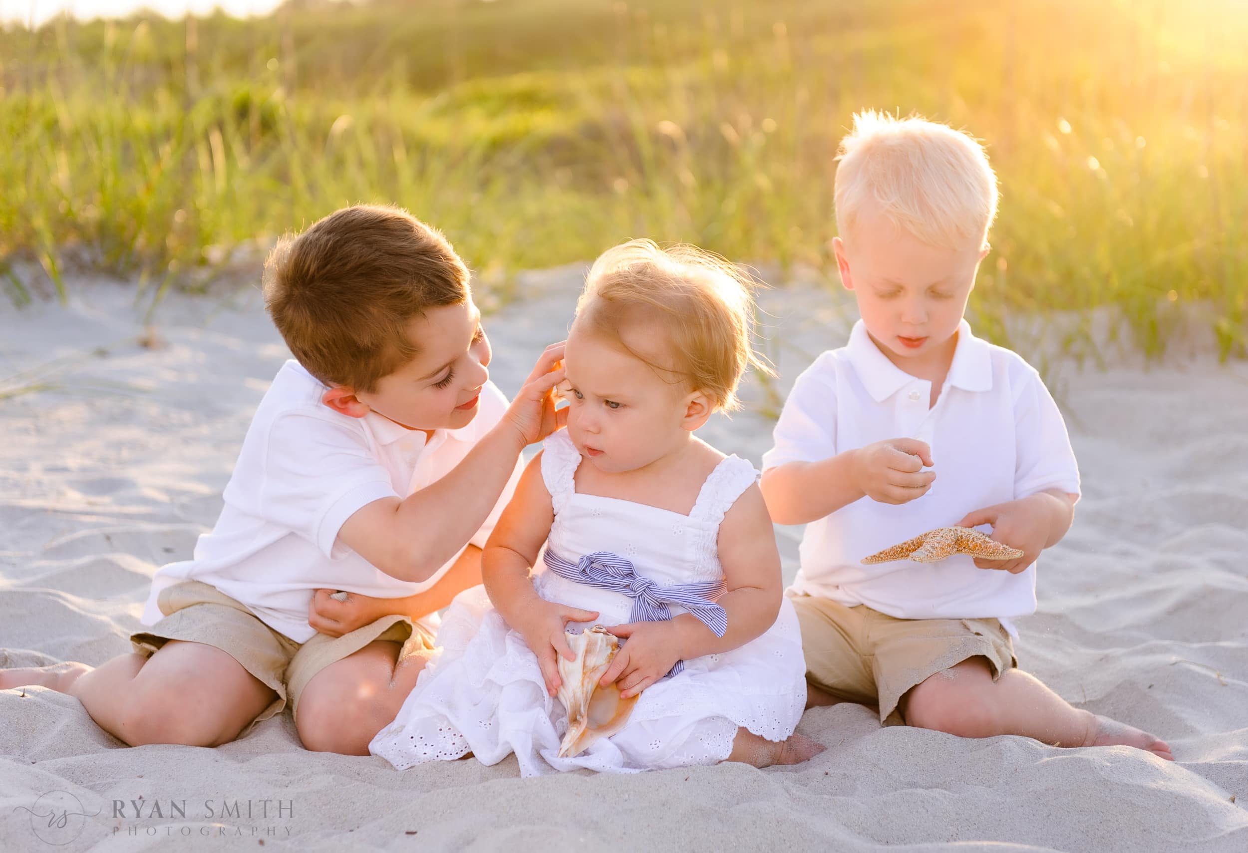 Brothers with baby sister playing with shells Myrtle Beach State Park
