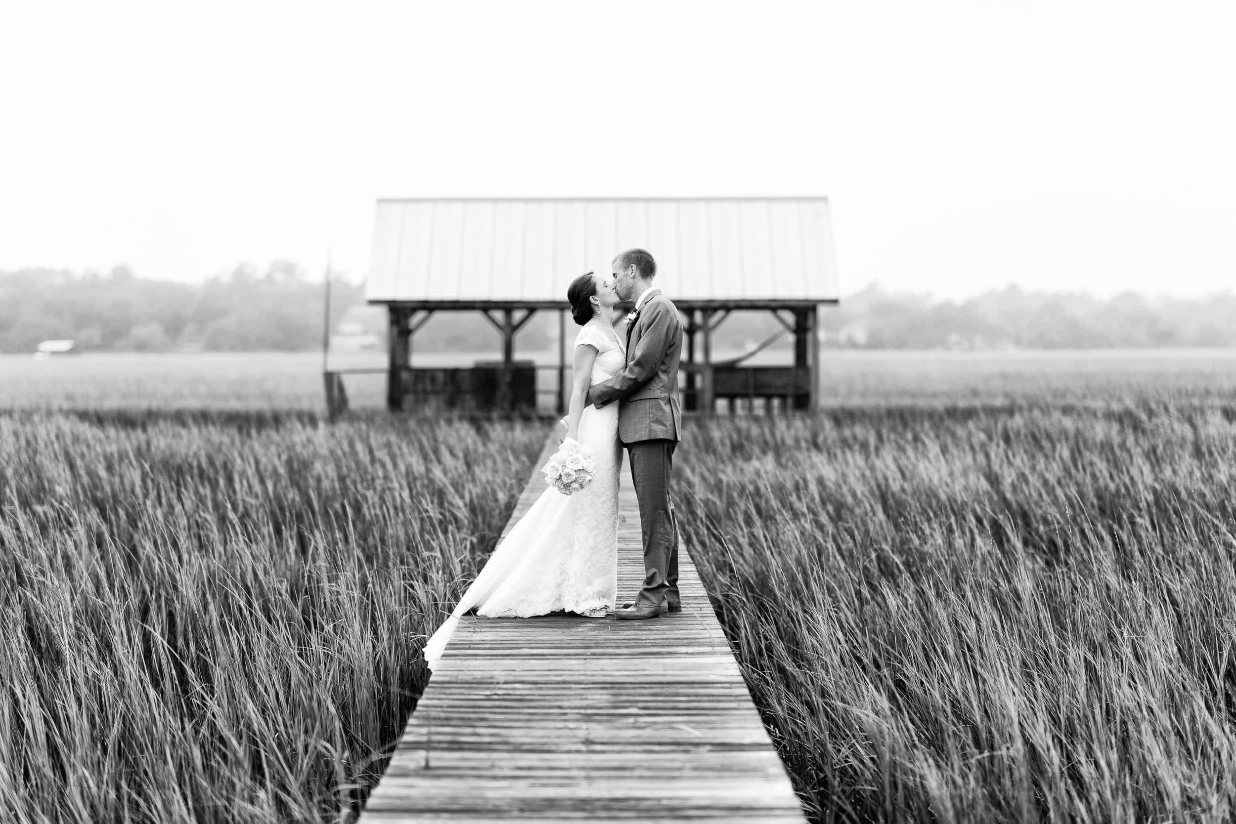 Couple kissing on a marsh walkway in black and white - The Pelican Inn