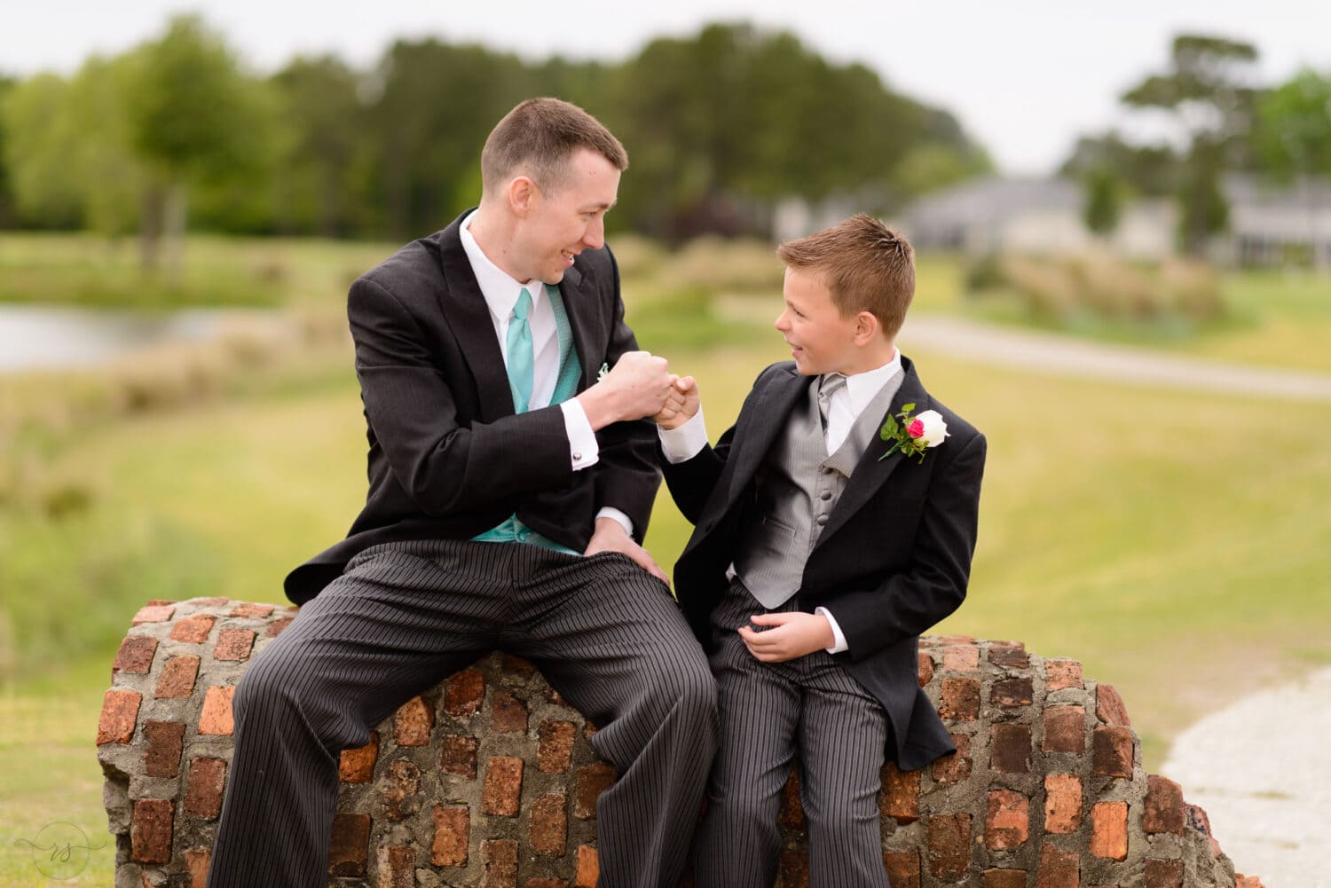 Groom and son having a fist bump before ceremony -