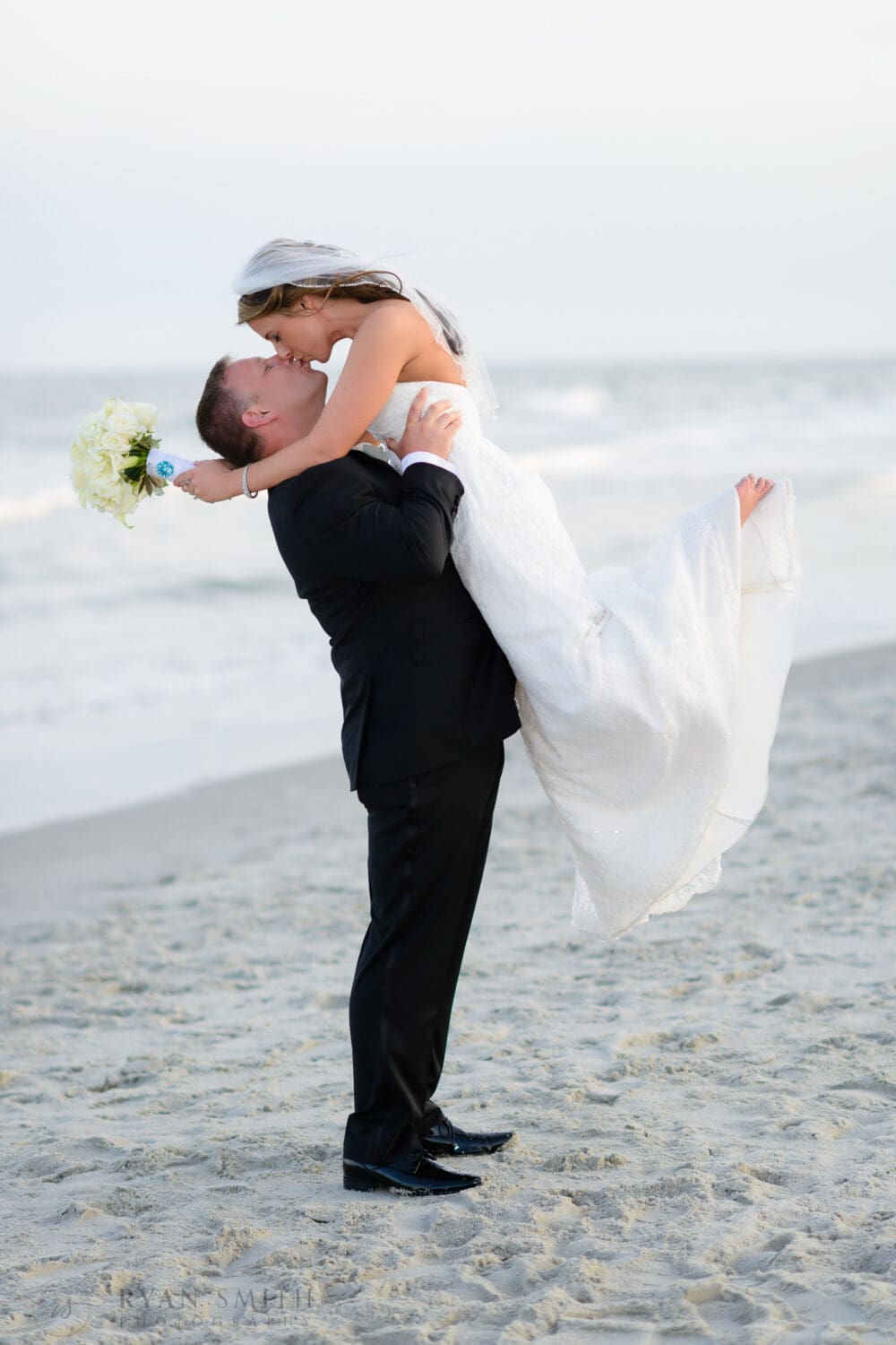 Groom lifting bride off the ground for a kiss - Ocean Club, Grande Dunes