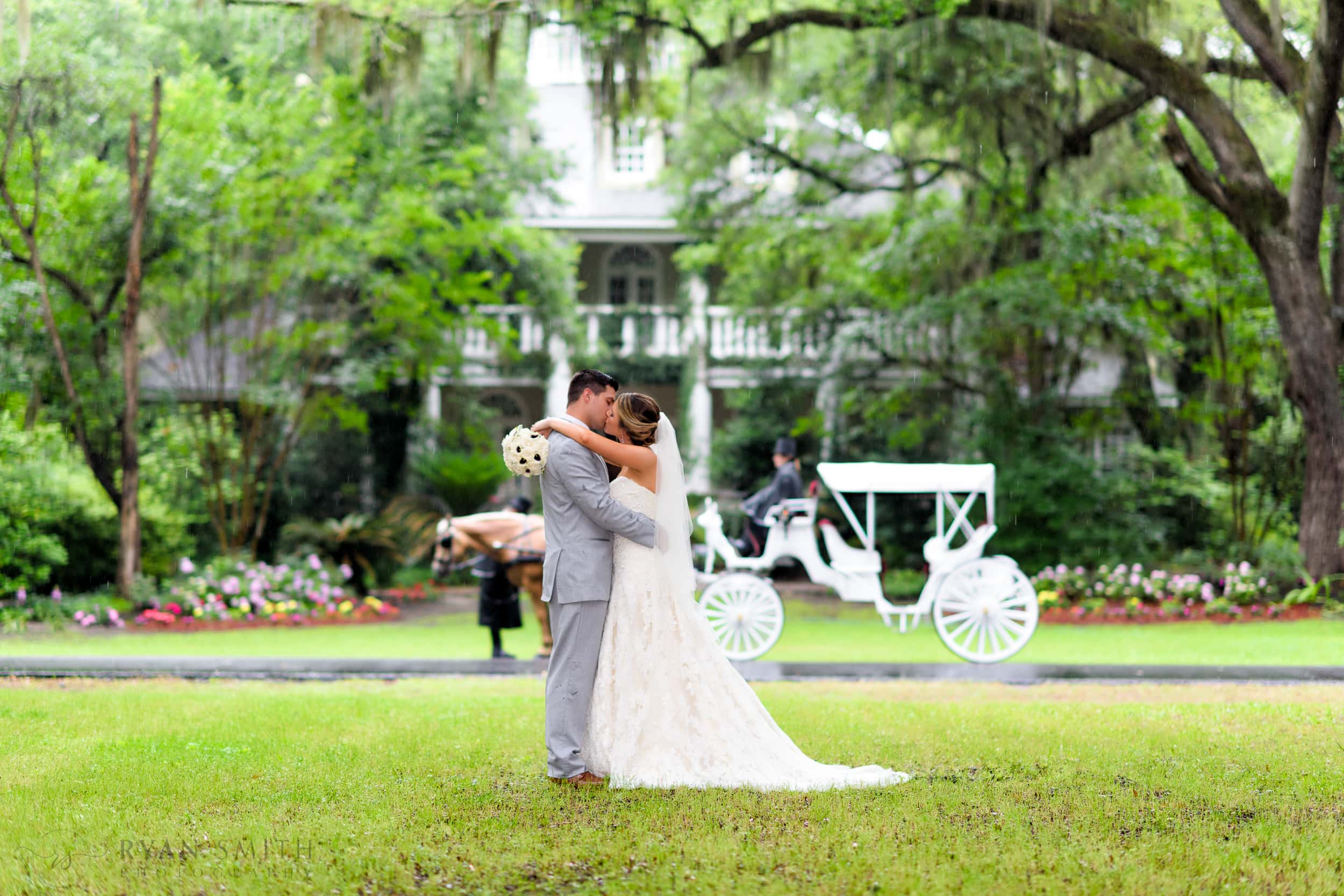 Kiss in the rain in front of a carriage - Wachesaw Plantation