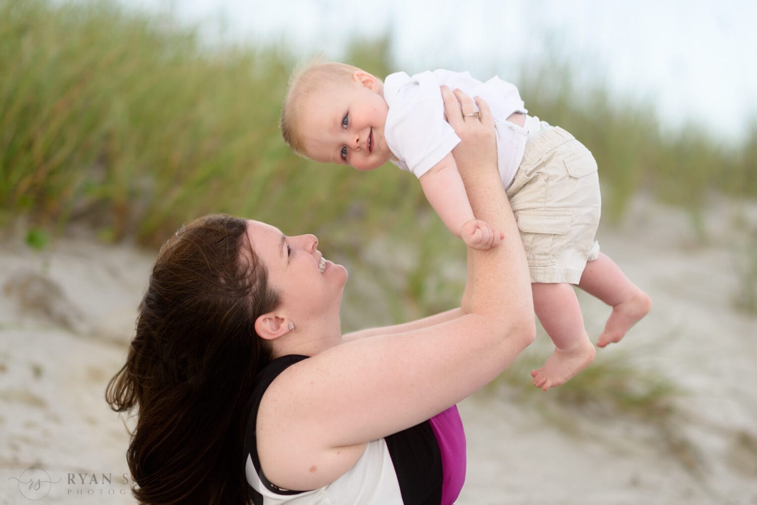 Mom lifting baby boy into the air - Myrtle Beach State Park
